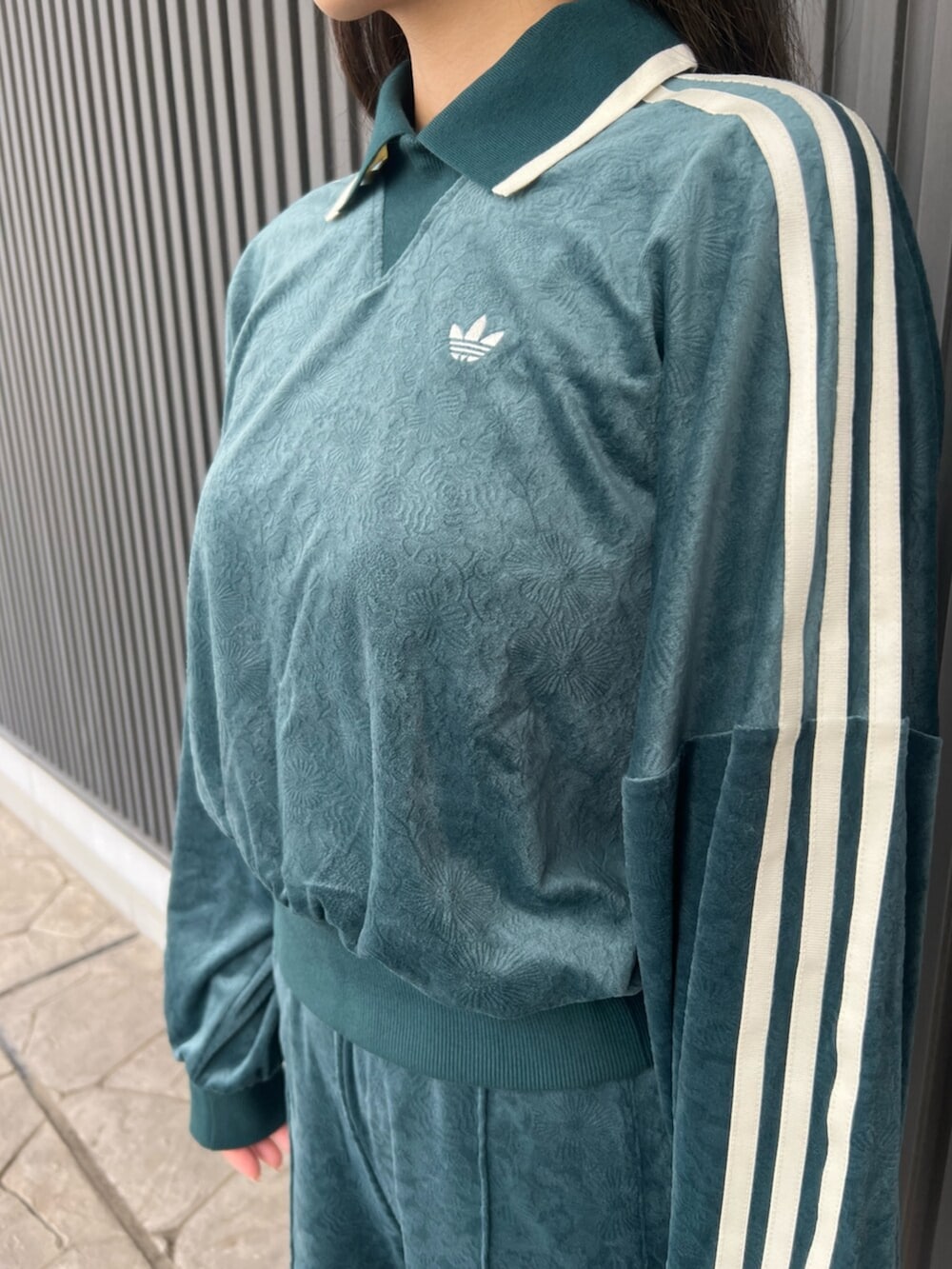 グリーン系のスウェット、グリーン系のその他パンツ、ホワイト系のシューズを着用したレディースの秋コーディネートの3枚目の写真