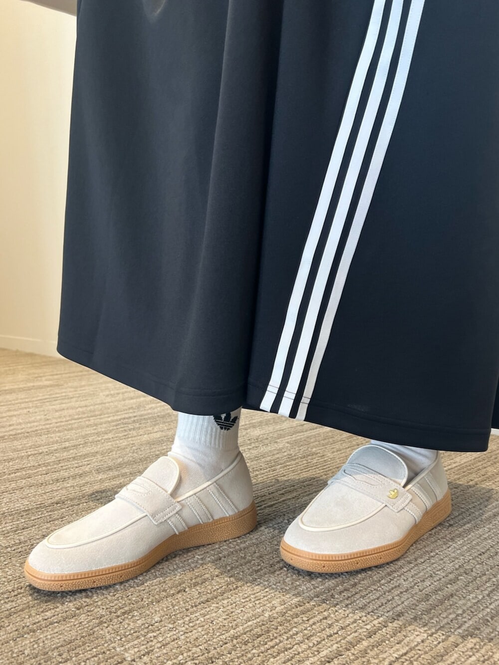 ブラック系のスカート、ホワイト系のスニーカー、シルバー系のショルダーバッグを着用したレディースの冬コーディネートの2枚目の写真