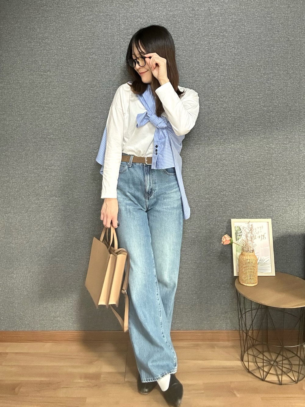 ブルー系のシャツ/ブラウス、ブラック系のTシャツ/カットソー、ブルー系のデニムパンツを着用したレディースの春コーディネートの2枚目の写真