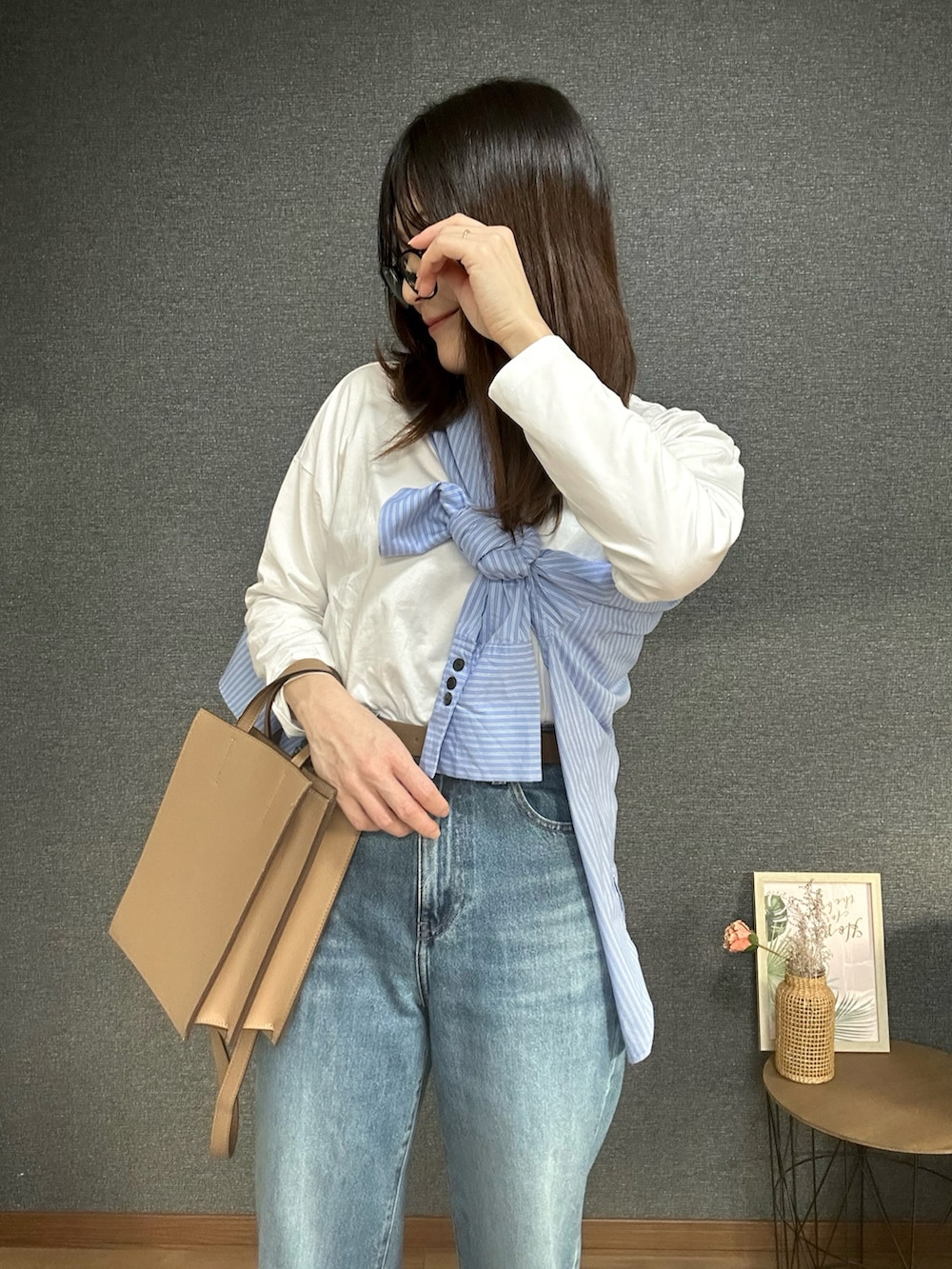 ブルー系のシャツ/ブラウス、ブラック系のTシャツ/カットソー、ブルー系のデニムパンツを着用したレディースの春コーディネートの3枚目の写真