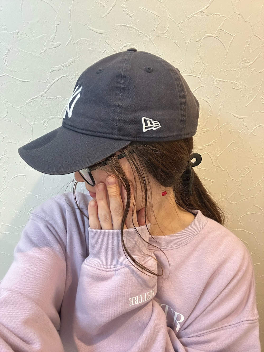 パープル系のスウェット、ブラウン系のショルダーバッグ、ブラック系のその他パンツを着用したレディースの冬コーディネートの4枚目の写真