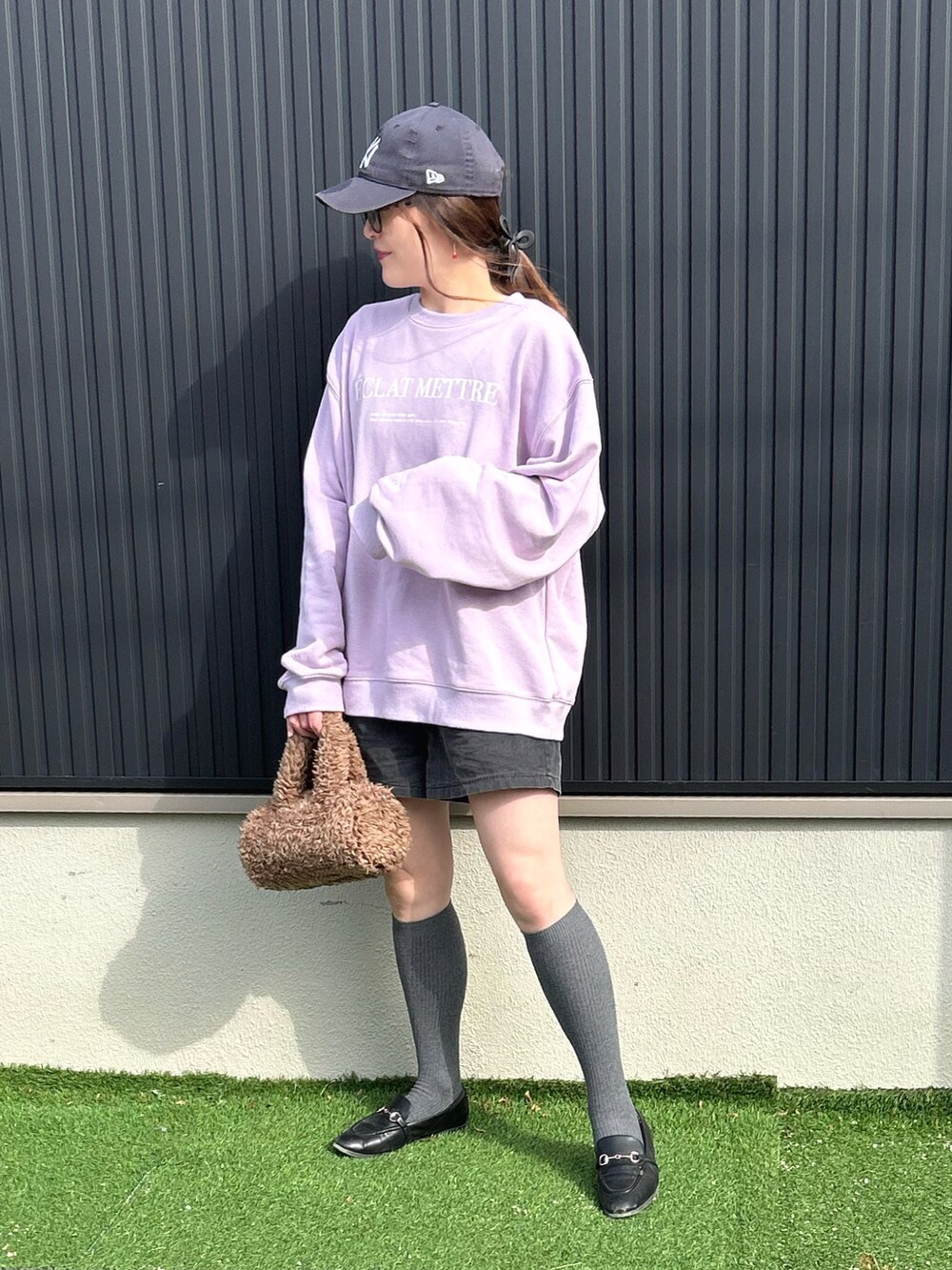 パープル系のスウェット、ブラウン系のショルダーバッグ、ブラック系のその他パンツを着用したレディースの冬コーディネートの3枚目の写真