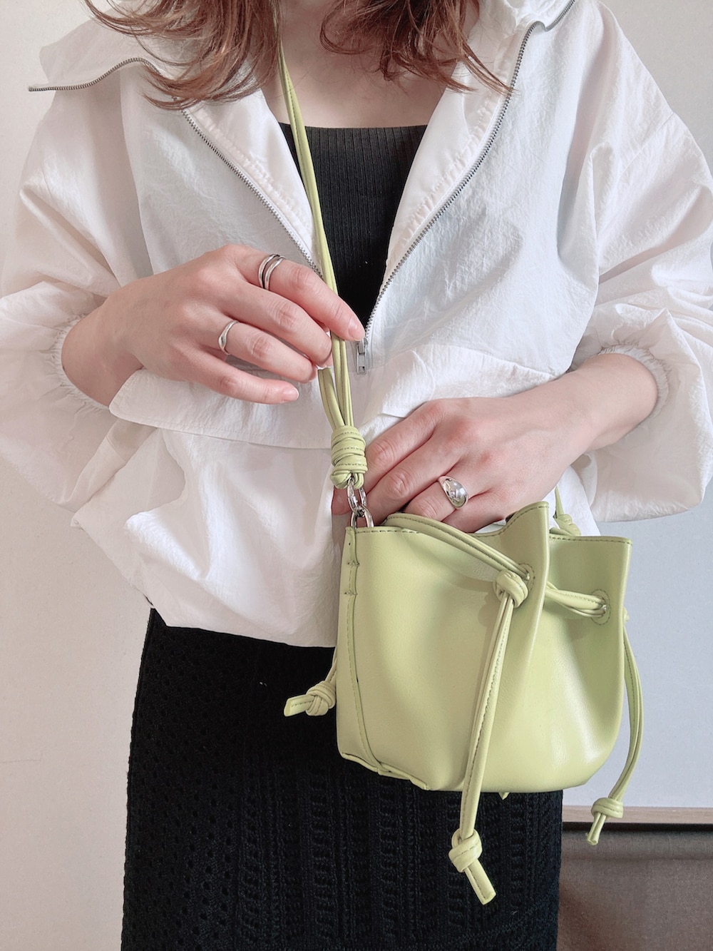 グリーン系のハンドバッグ、ブラック系のスニーカー、イエロー系のソックス/靴下を着用したレディースの春コーディネートの3枚目の写真