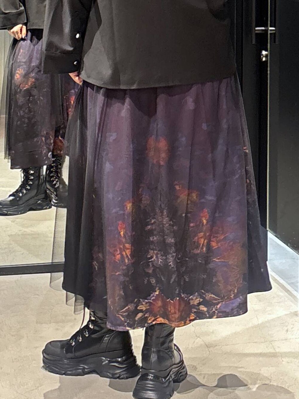 パープル系のスカートを着用したレディースの秋コーディネートの5枚目の写真