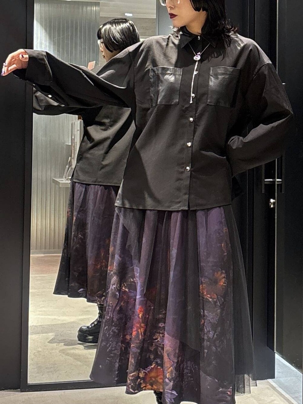 パープル系のスカートを着用したレディースの秋コーディネートの4枚目の写真