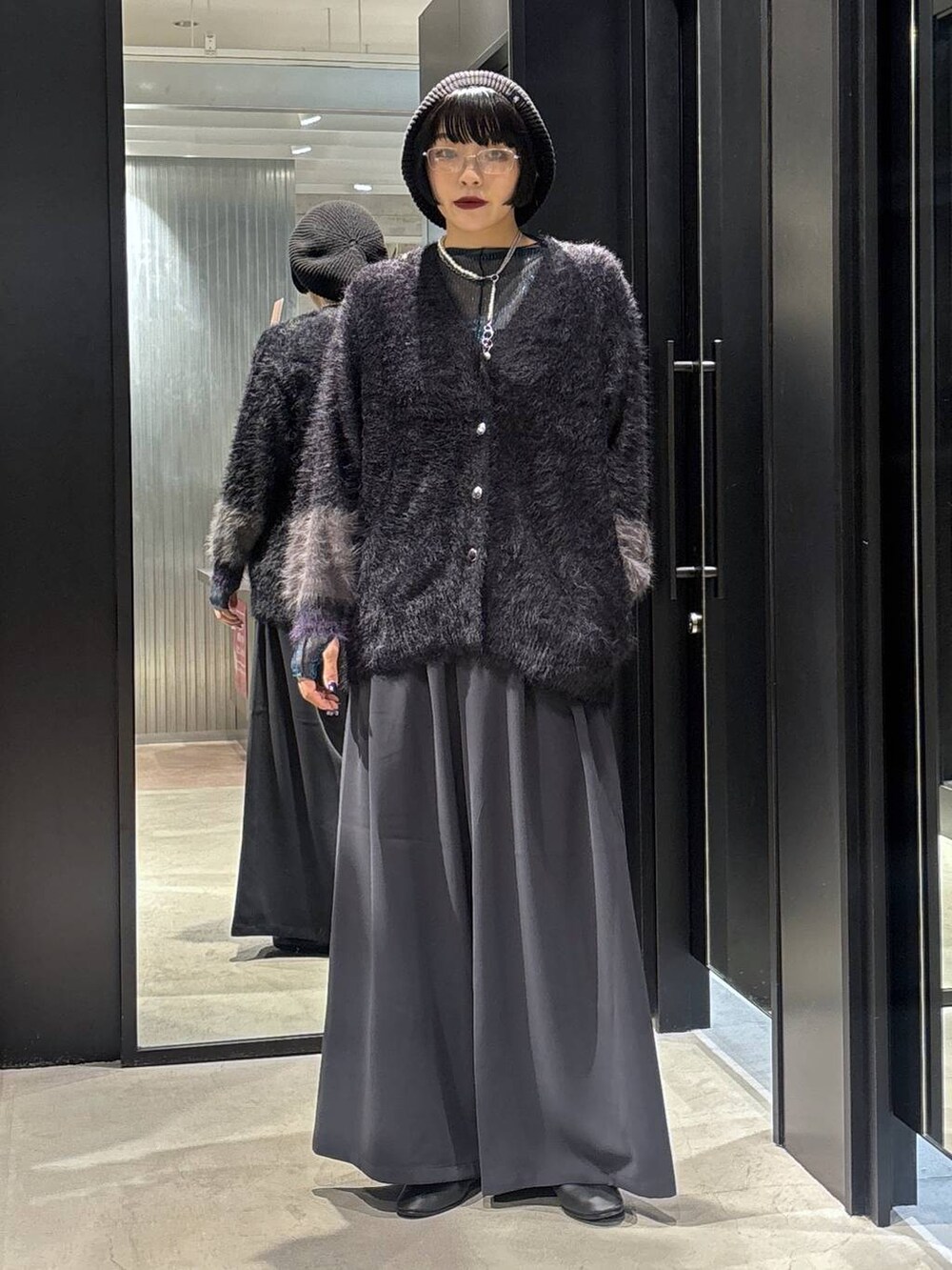 グレー系のスラックス、ブルー系のTシャツ/カットソー、ブラック系のカーディガン/ボレロを着用したレディースの秋コーディネートの3枚目の写真