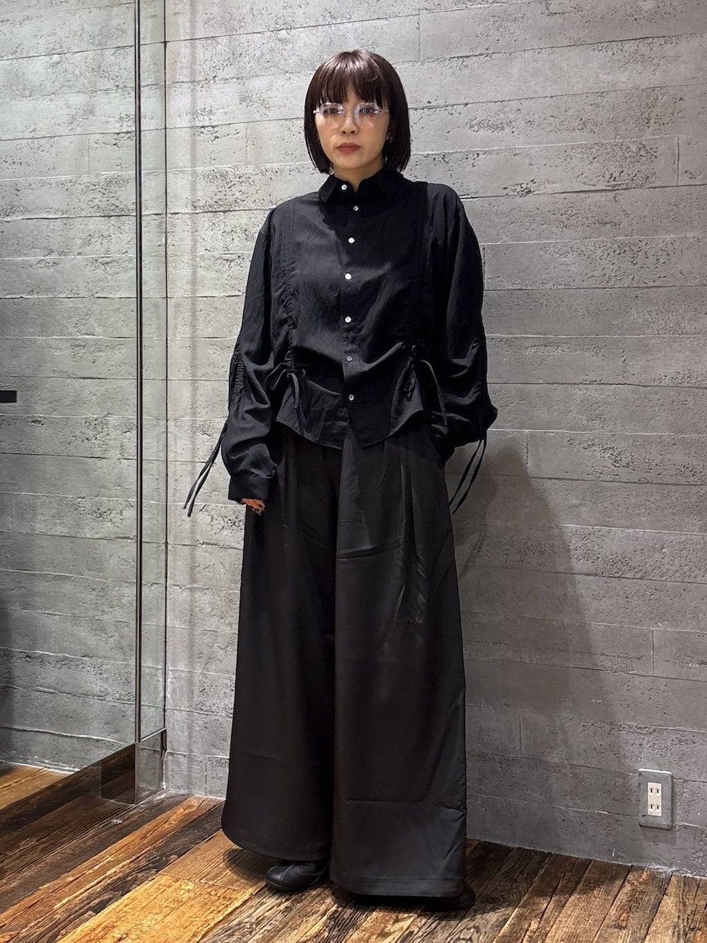 ブラック系のスラックス、ブラック系のシャツ/ブラウス、シルバー系のメガネを着用したレディースの春コーディネートの2枚目の写真