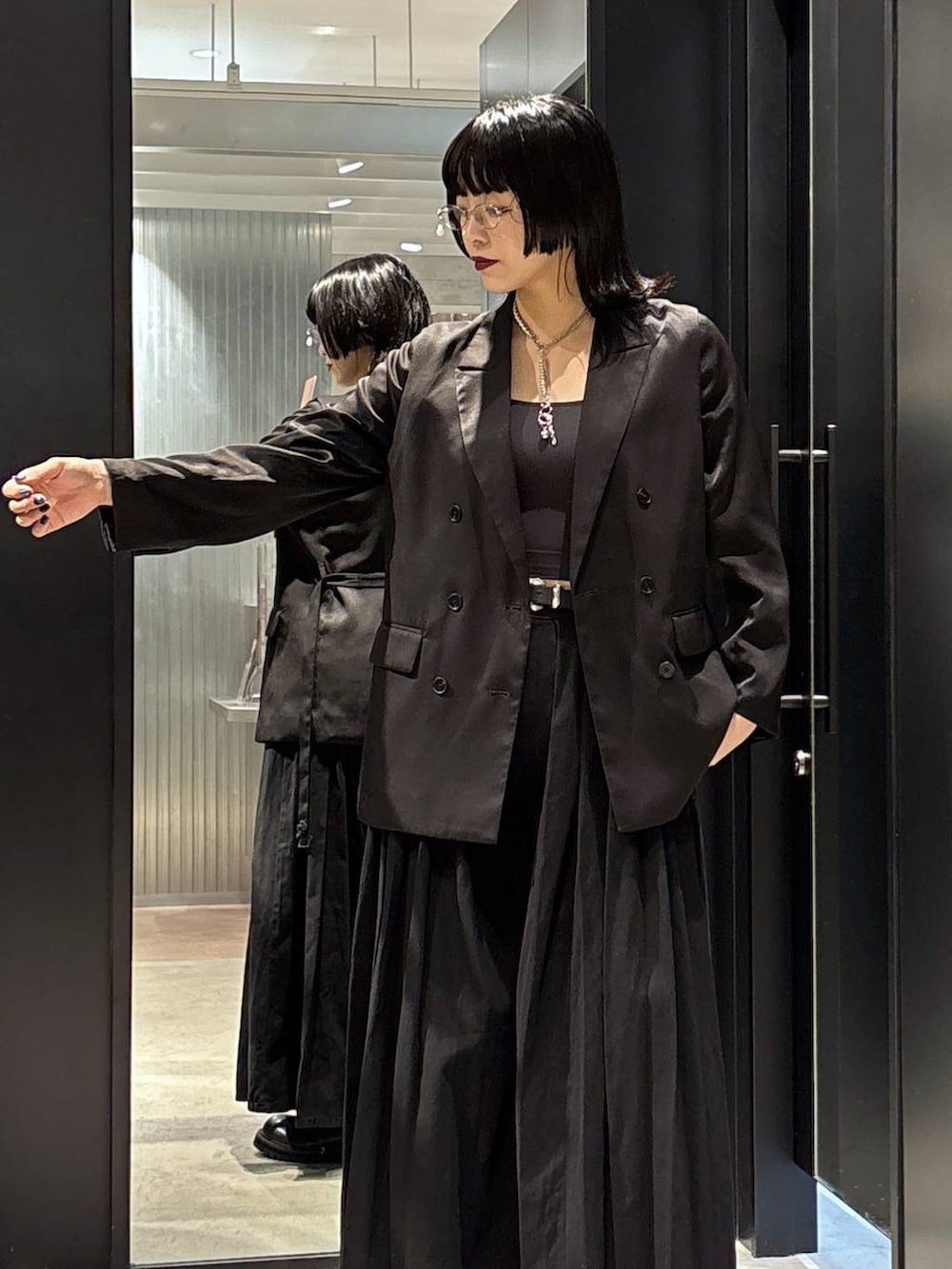 ブラック系のテーラードジャケット、ブラック系のデニムパンツ、ブラック系のブーツを着用したレディースの秋コーディネートの4枚目の写真