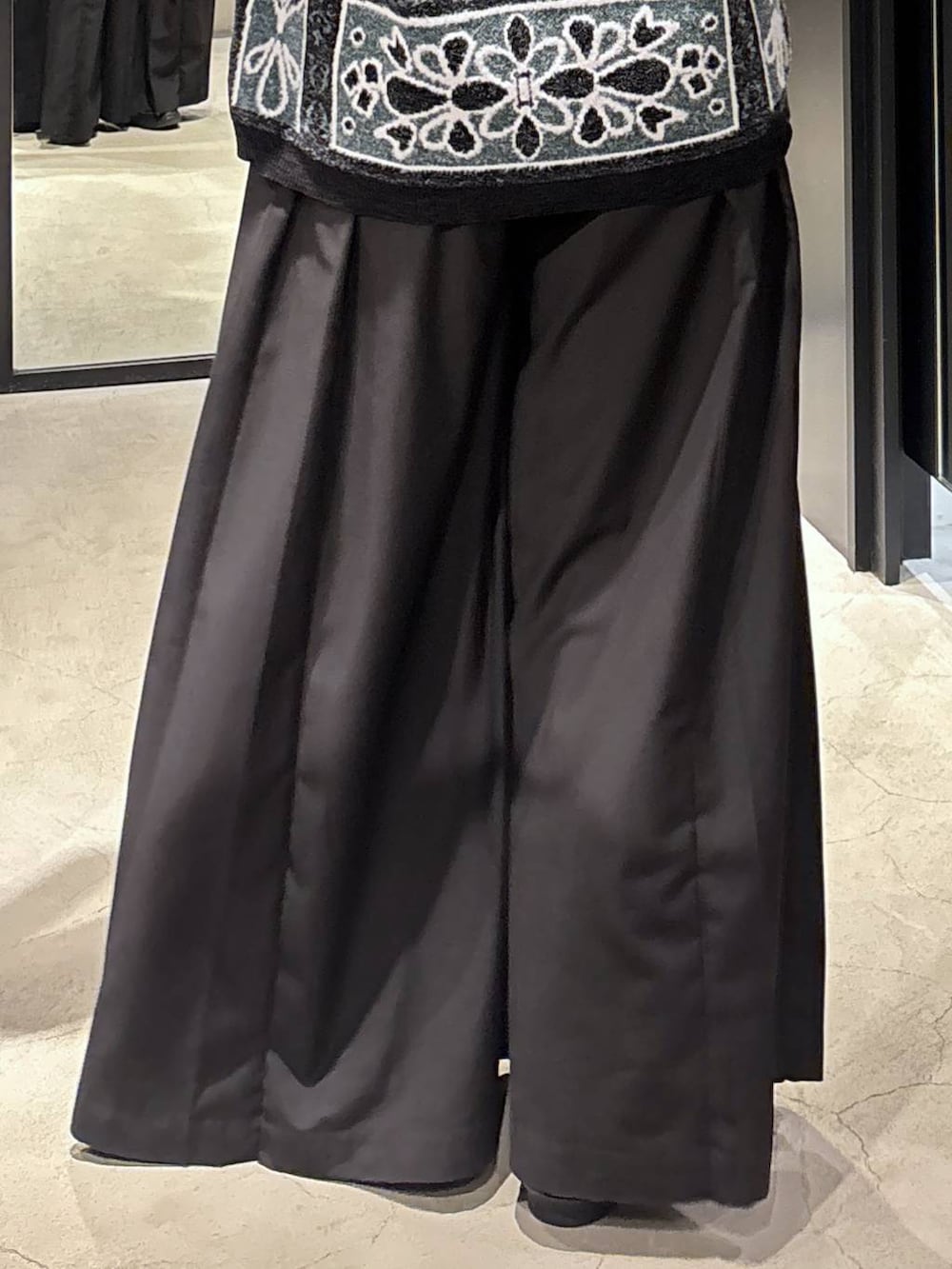 ブラック系のチェスターコート、ブラック系のバレエシューズ、ブラック系のその他パンツを着用したレディースの秋コーディネートの8枚目の写真