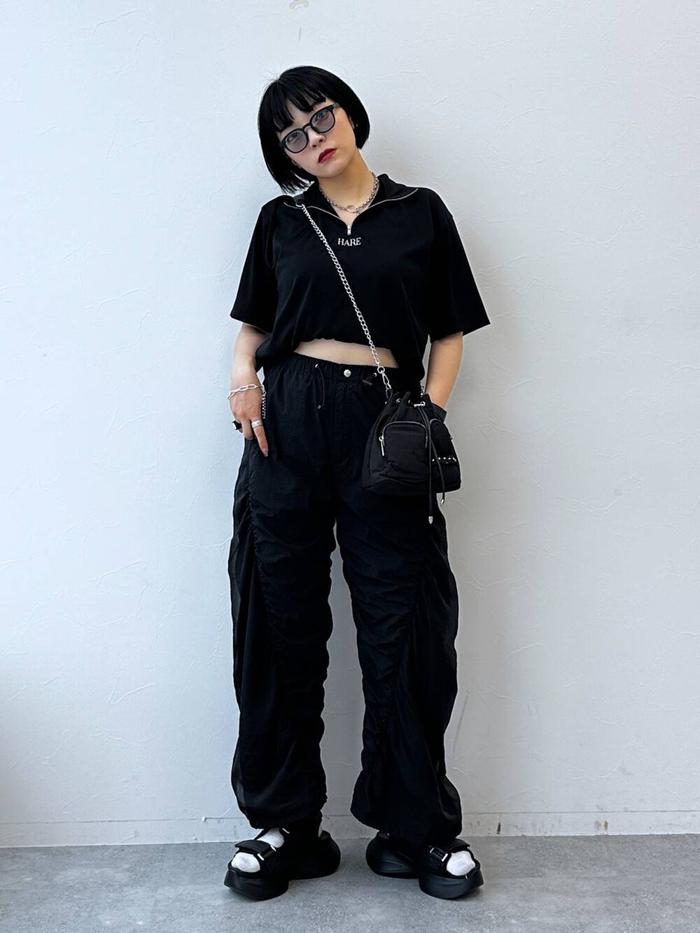 ブラック系のサンダル、ブラック系のTシャツ/カットソー、ブラック系のショルダーバッグを着用したレディースの夏コーディネートの2枚目の写真