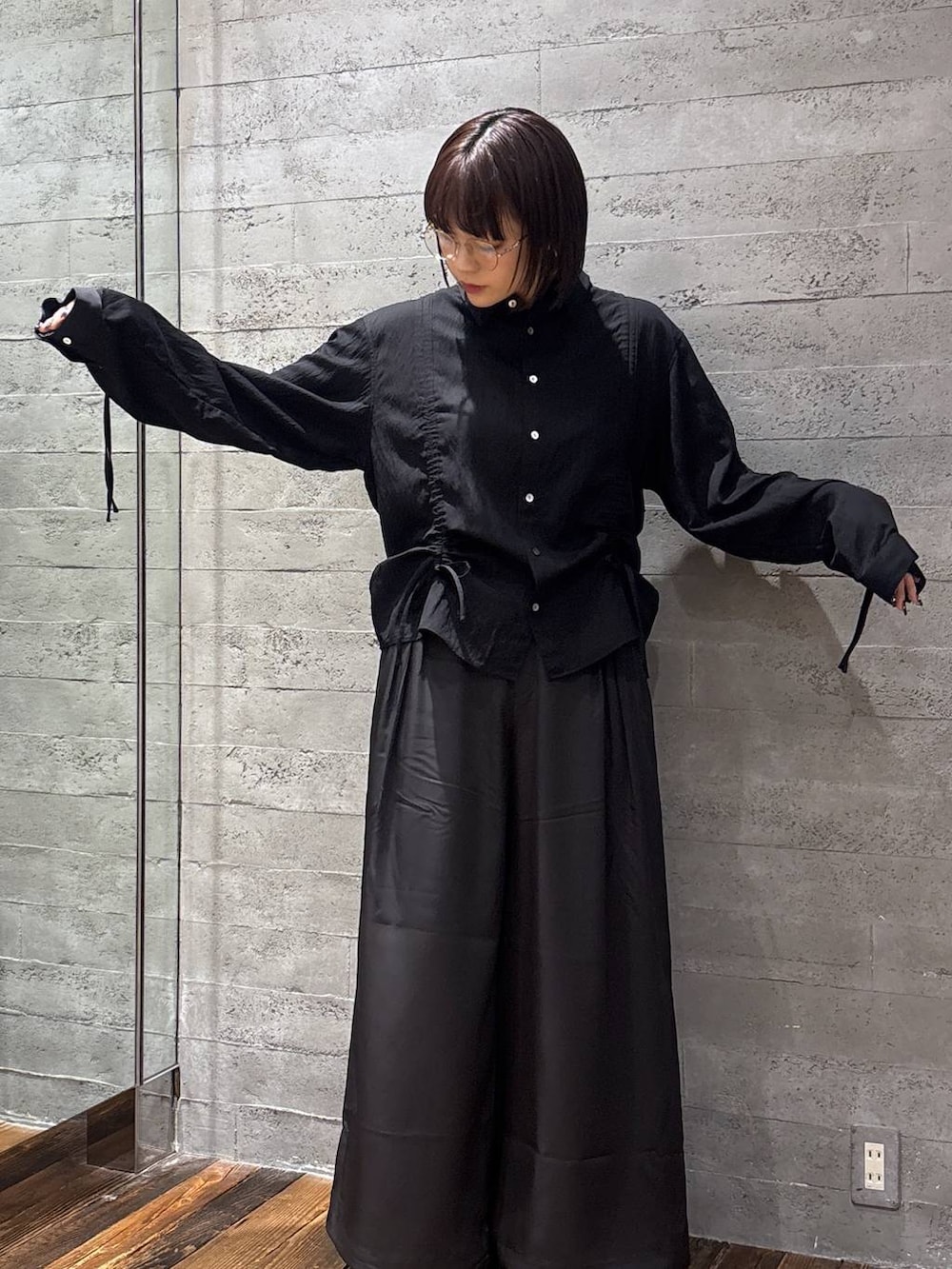 ブラック系のスラックス、ブラック系のシャツ/ブラウス、シルバー系のメガネを着用したレディースの春コーディネートの4枚目の写真