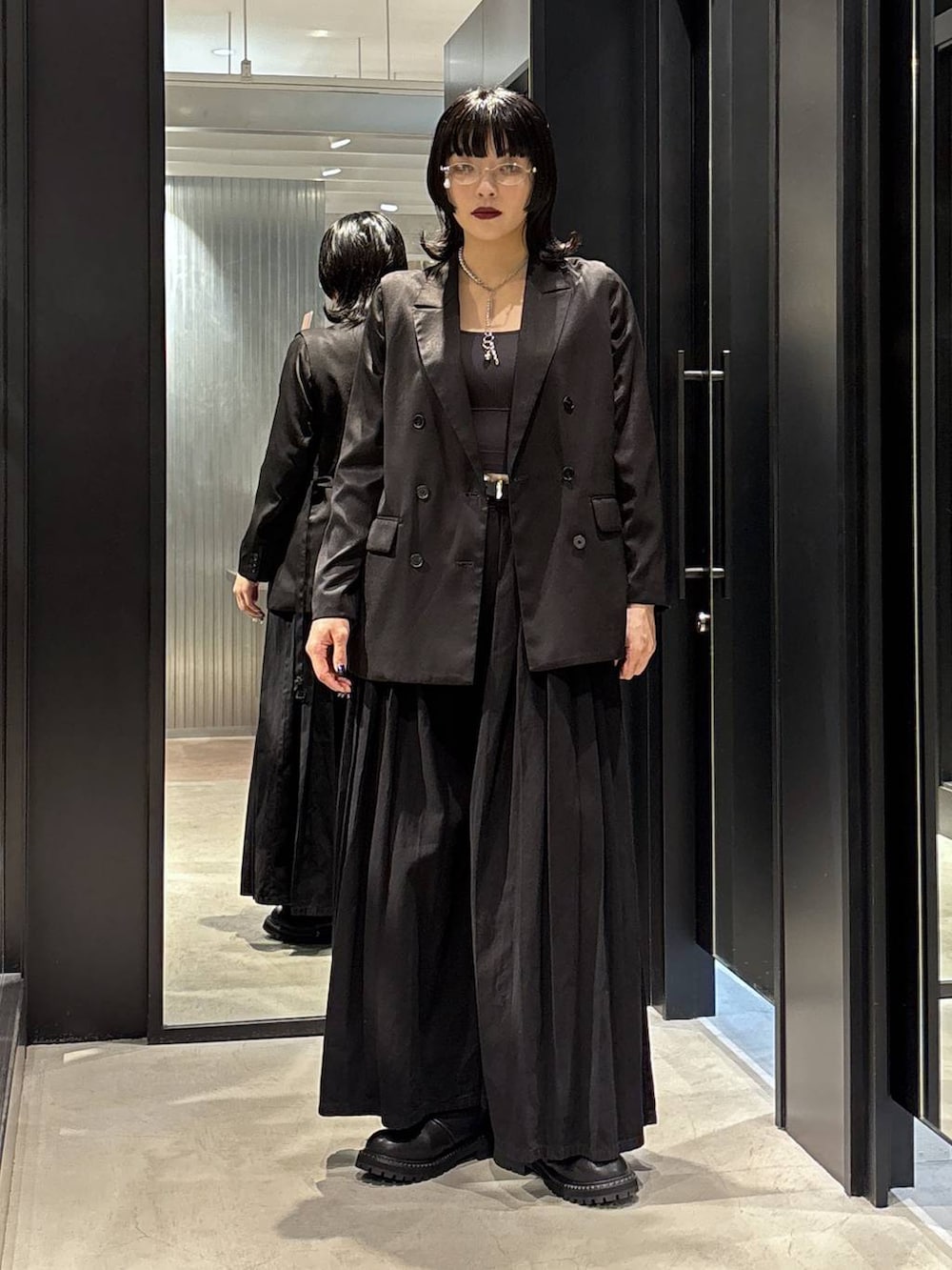 ブラック系のテーラードジャケット、ブラック系のデニムパンツ、ブラック系のブーツを着用したレディースの秋コーディネートの3枚目の写真