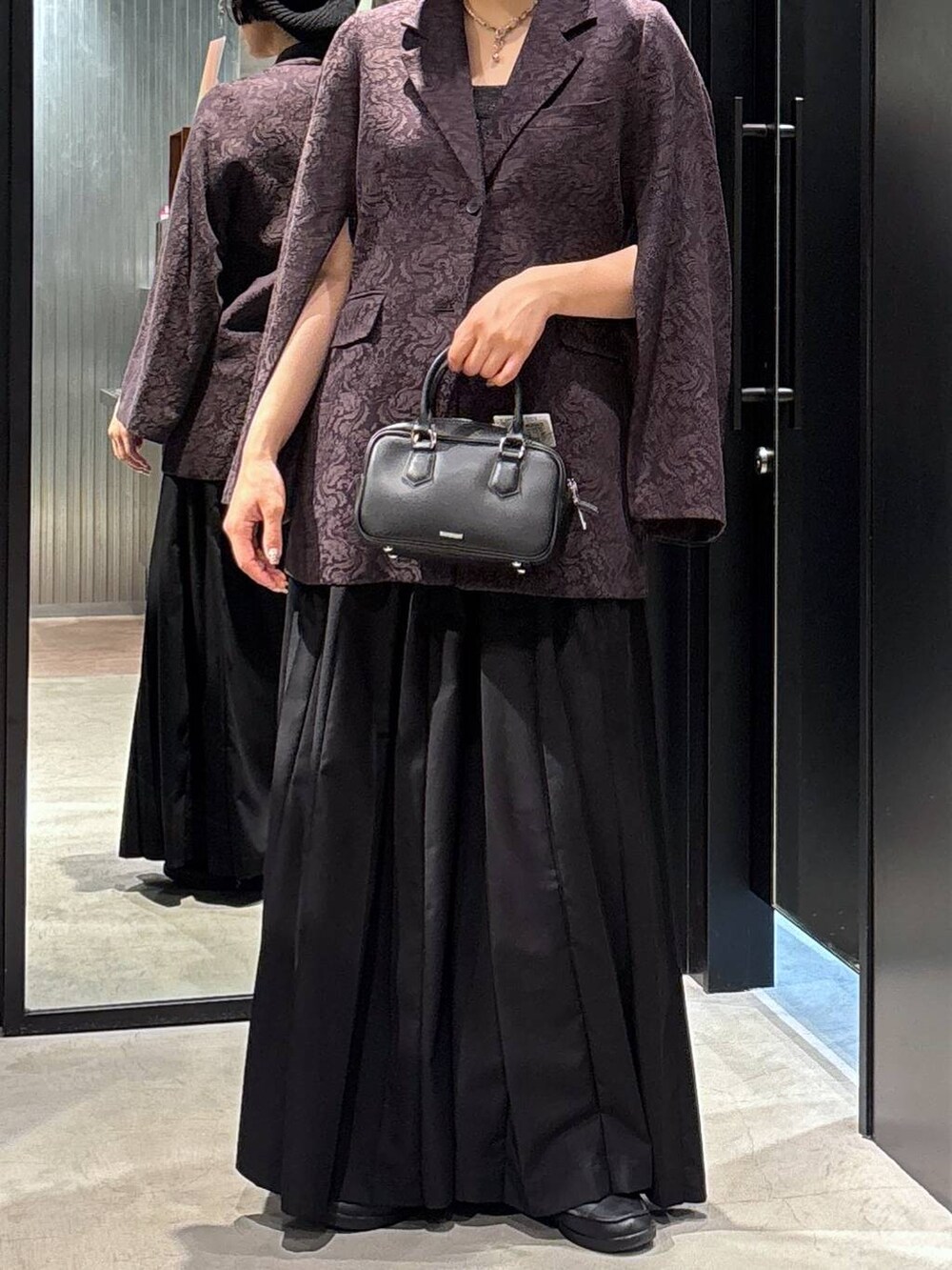 ブラック系のその他パンツ、ブラック系のボストンバッグ、ブラウン系のテーラードジャケットを着用したレディースの夏コーディネートの3枚目の写真