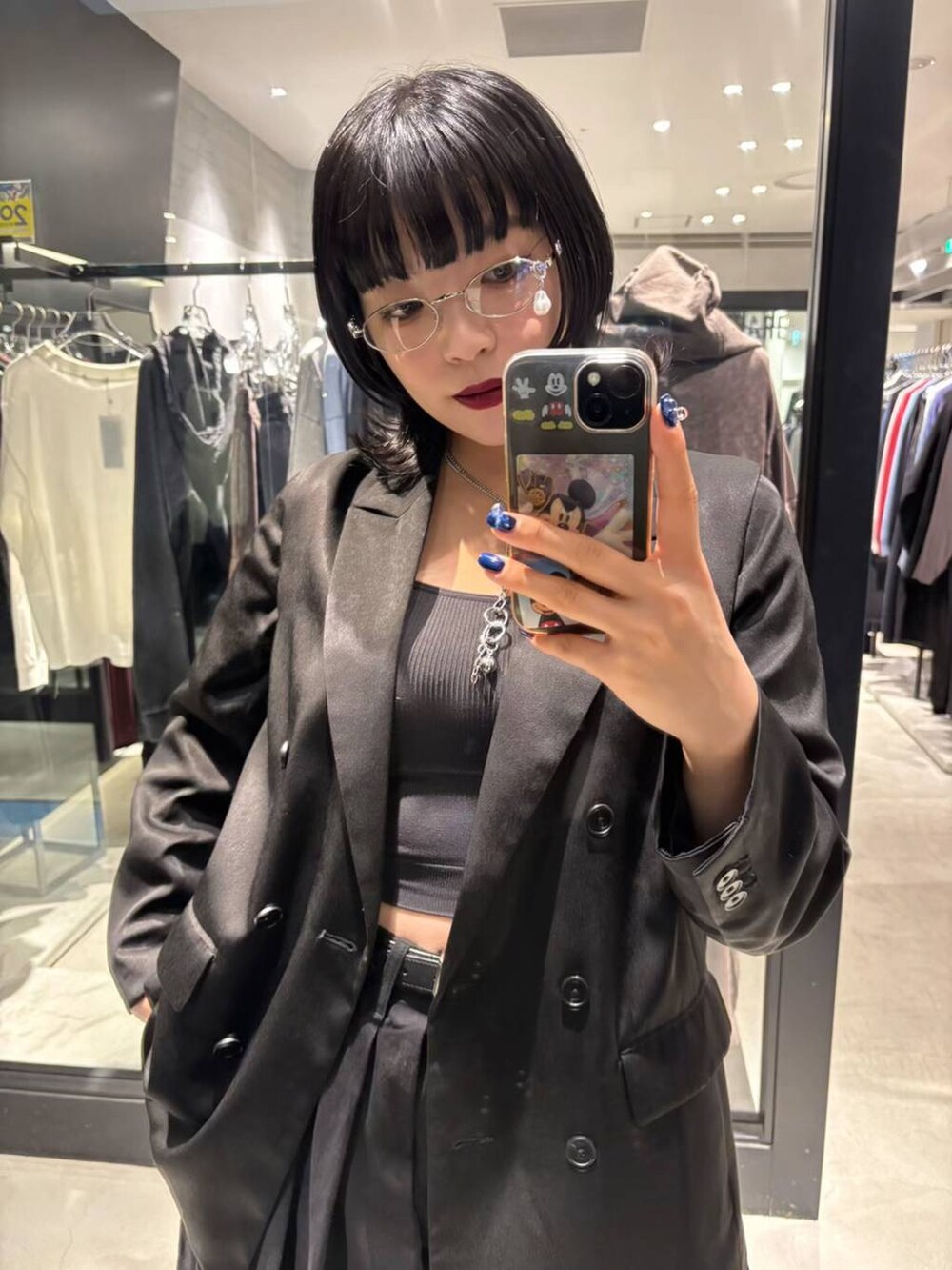 ブラック系のテーラードジャケット、ブラック系のデニムパンツ、ブラック系のブーツを着用したレディースの秋コーディネートの6枚目の写真