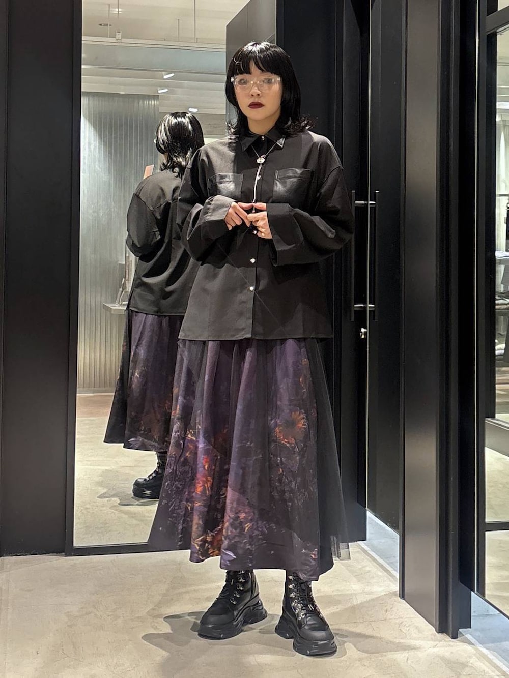 パープル系のスカートを着用したレディースの秋コーディネートの3枚目の写真