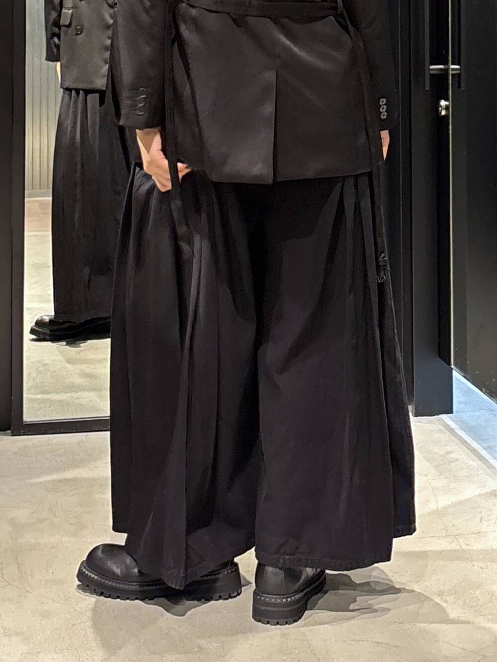 ブラック系のテーラードジャケット、ブラック系のデニムパンツ、ブラック系のブーツを着用したレディースの秋コーディネートの5枚目の写真