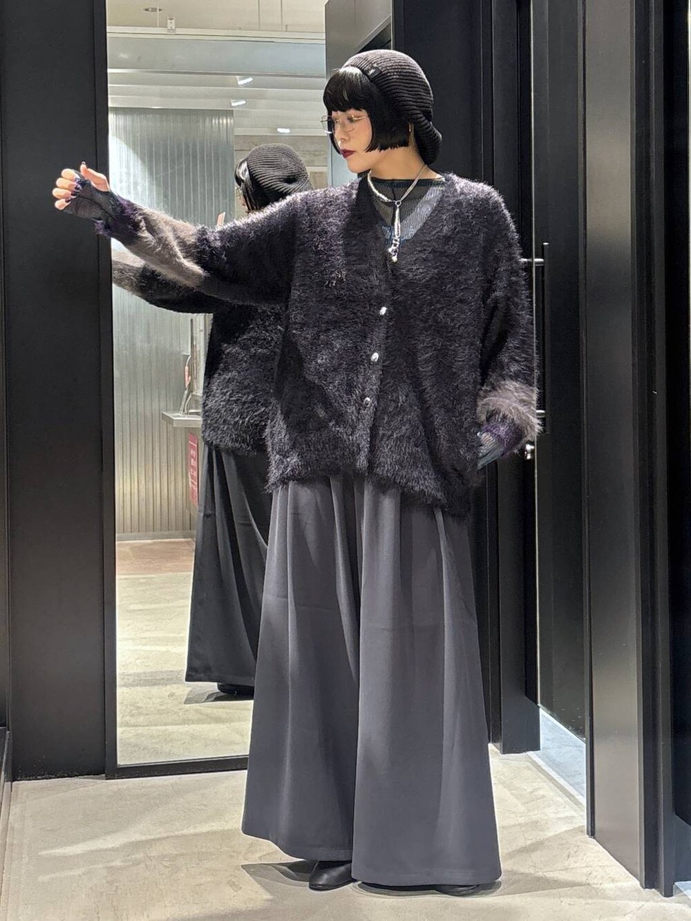 グレー系のスラックス、ブルー系のTシャツ/カットソー、ブラック系のカーディガン/ボレロを着用したレディースの秋コーディネートの2枚目の写真