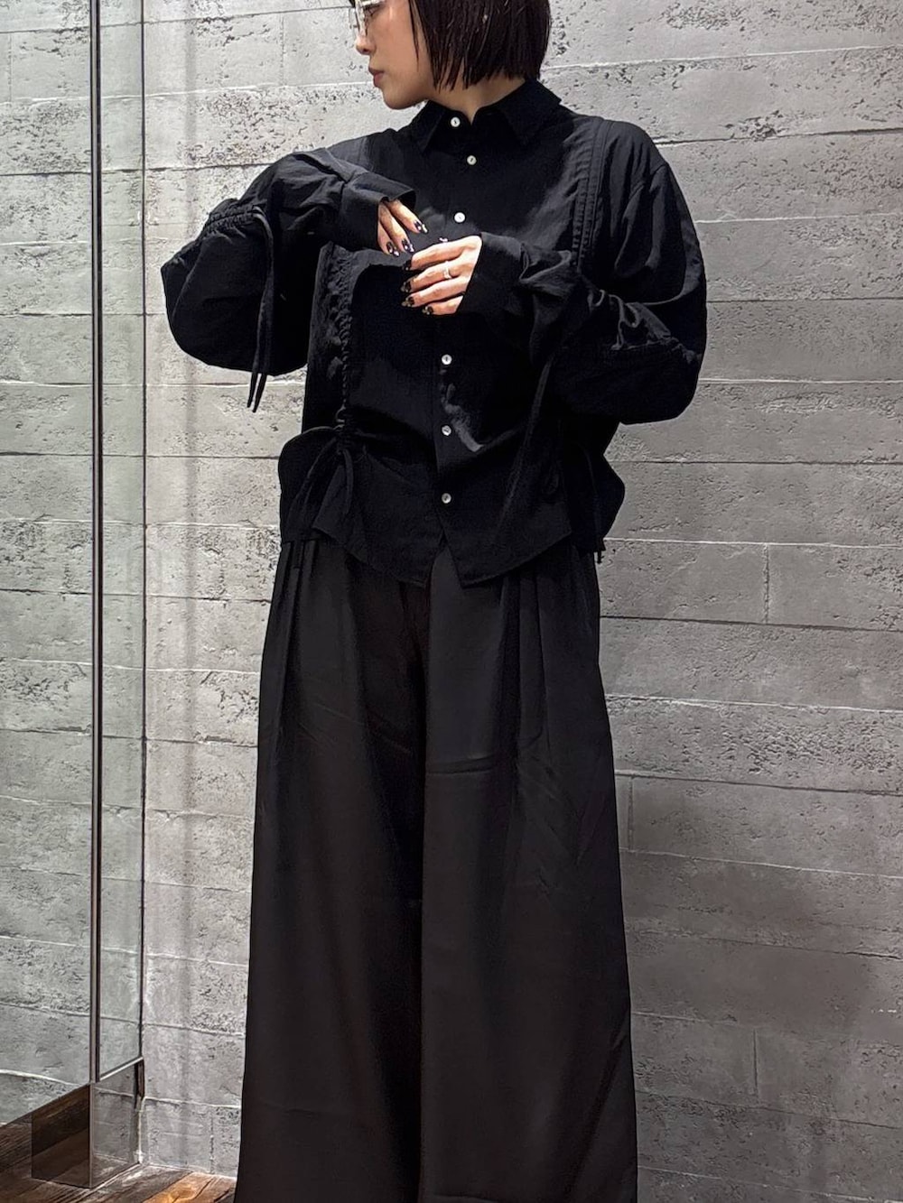 ブラック系のスラックス、ブラック系のシャツ/ブラウス、シルバー系のメガネを着用したレディースの春コーディネートの3枚目の写真