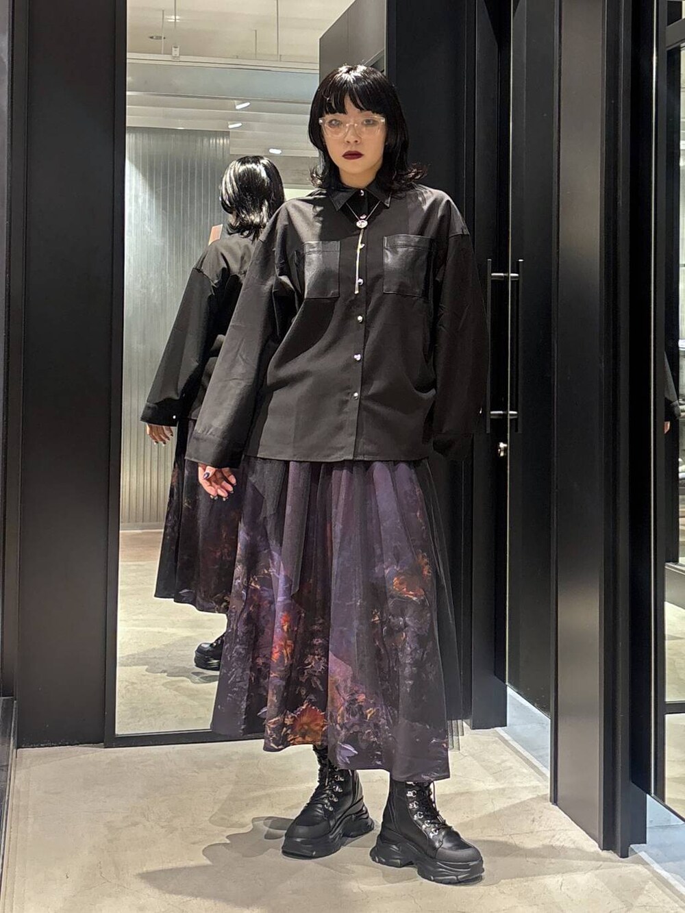 パープル系のスカートを着用したレディースの秋コーディネートの2枚目の写真