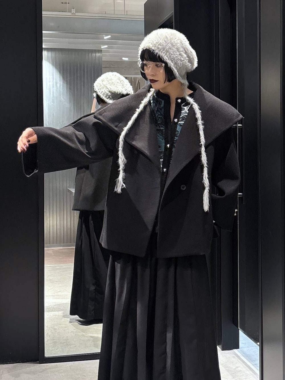 ブラック系のチェスターコート、ブラック系のバレエシューズ、ブラック系のその他パンツを着用したレディースの秋コーディネートの4枚目の写真