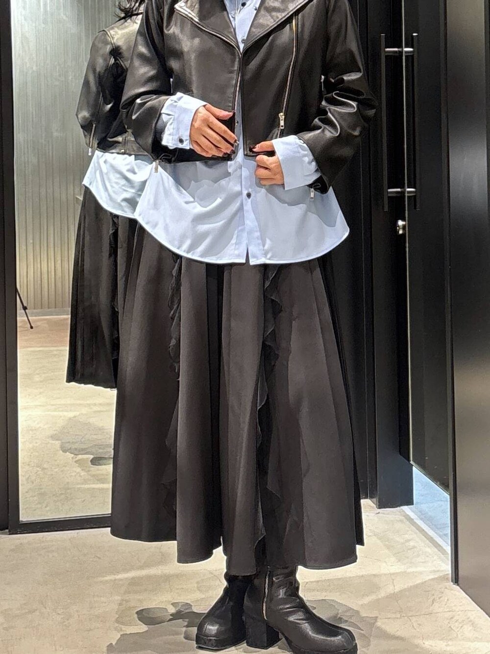 ブラック系のスカート、ブラック系のライダースジャケット、ブラック系のブーツを着用したレディースの秋コーディネートの4枚目の写真