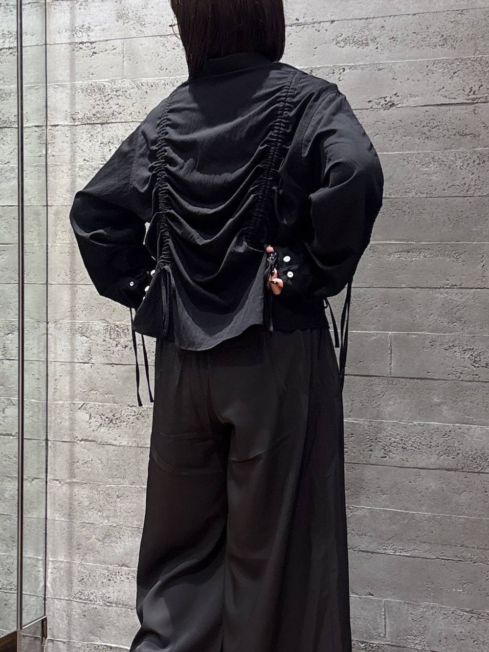 ブラック系のスラックス、ブラック系のシャツ/ブラウス、シルバー系のメガネを着用したレディースの春コーディネートの5枚目の写真