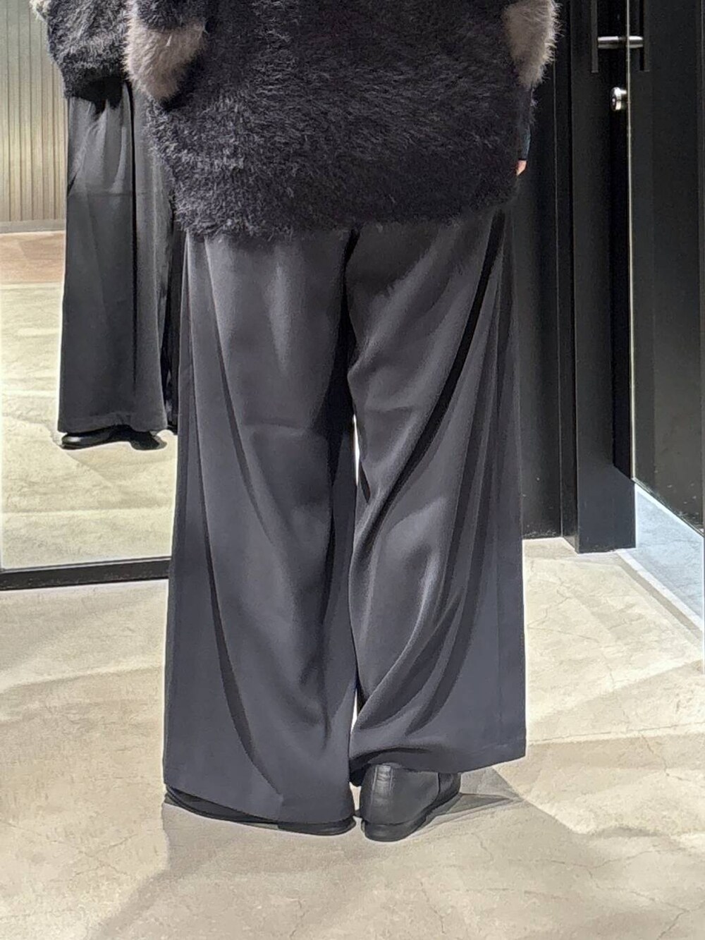 グレー系のスラックス、ブルー系のTシャツ/カットソー、ブラック系のカーディガン/ボレロを着用したレディースの秋コーディネートの5枚目の写真