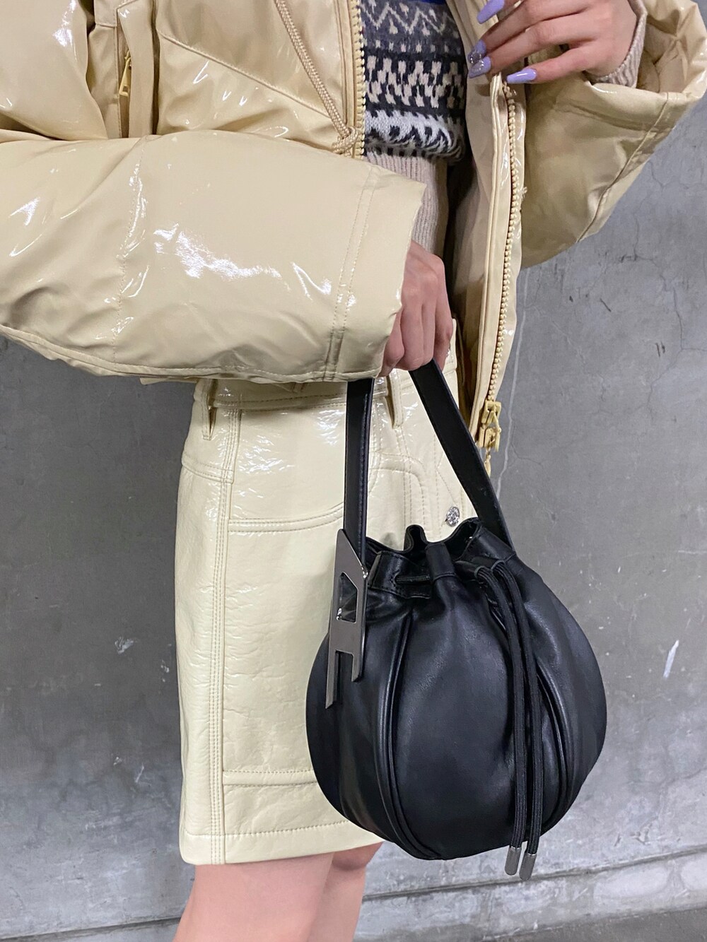 ベージュ系のダウンジャケット/コート、ホワイト系のニット/セーター、ホワイト系のスカートを着用したレディースの冬コーディネートの2枚目の写真