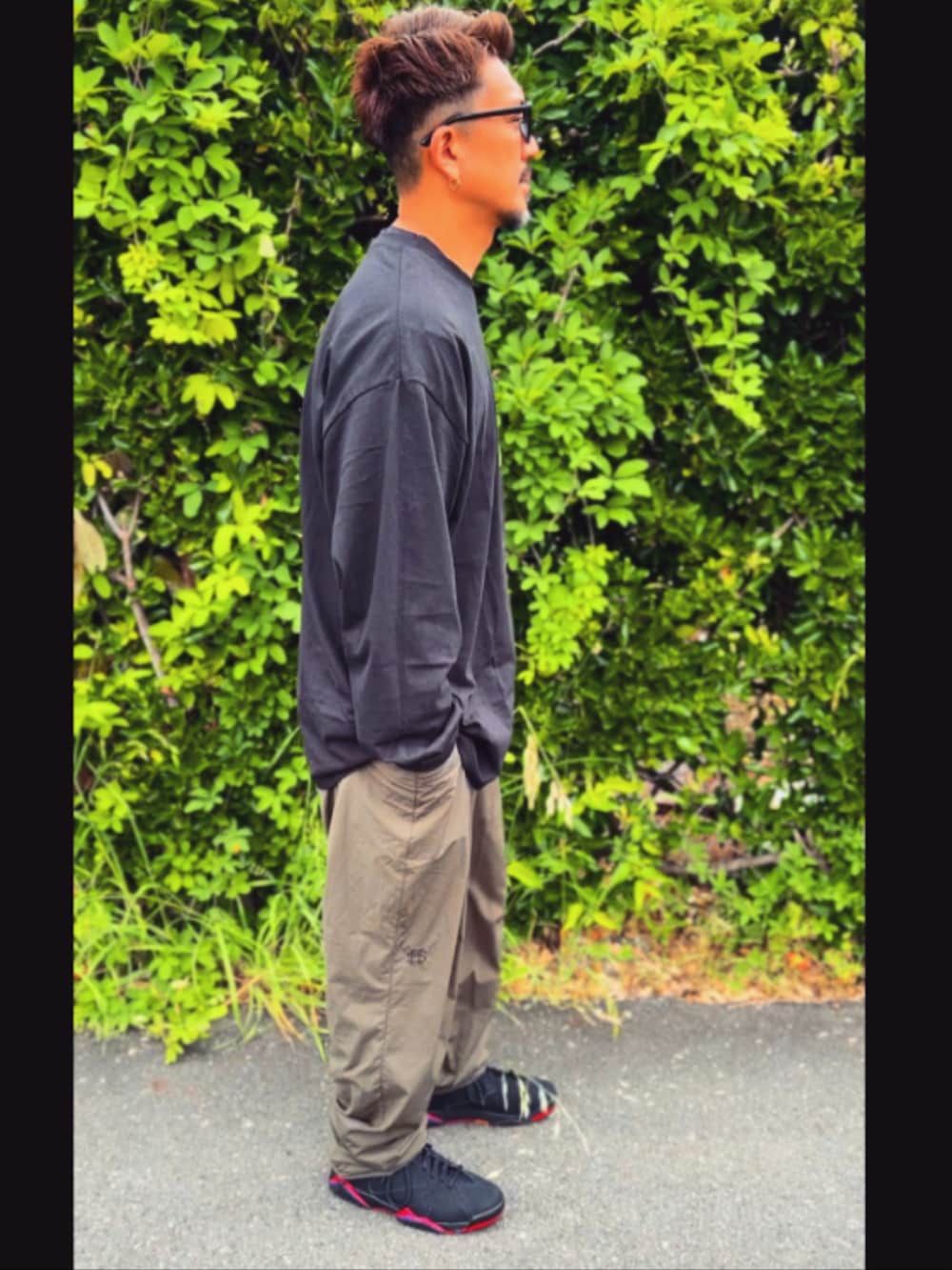 ブラック系のTシャツ/カットソー、グリーン系のその他パンツ、ブラック系のスニーカーを着用したメンズの春コーディネートの5枚目の写真