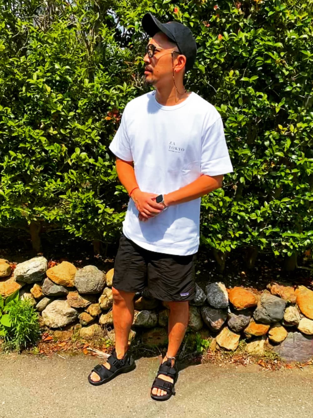 ホワイト系のTシャツ/カットソー、ブラック系のその他パンツ、ブラック系のサンダルを着用したメンズの夏コーディネートの2枚目の写真