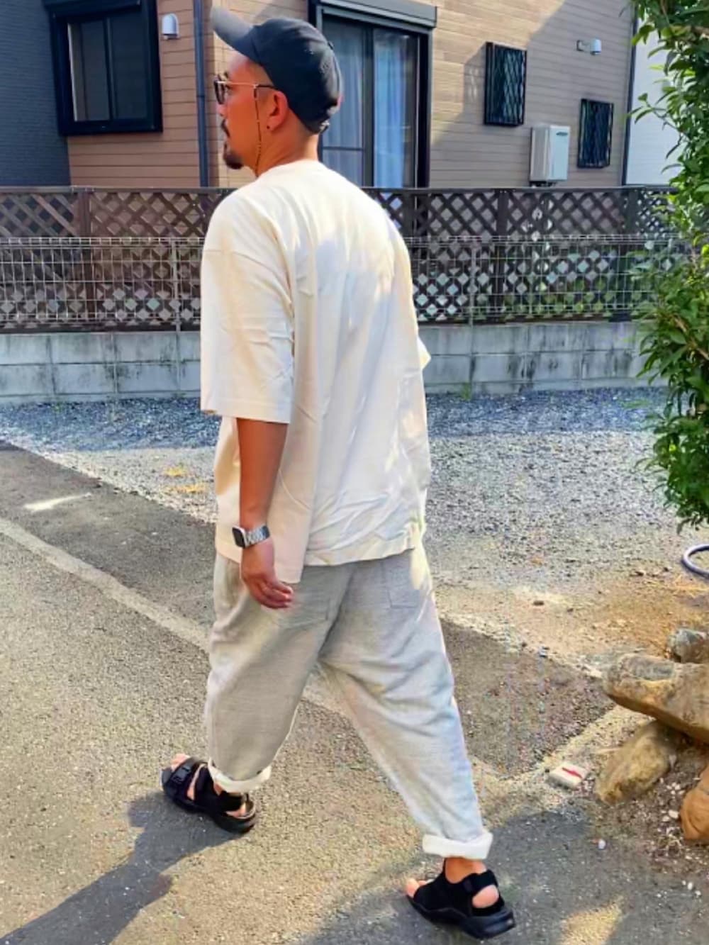 ブラック系のTシャツ/カットソー、シルバー系のスウェットパンツ、ブラック系のサンダルを着用したメンズの夏コーディネートの5枚目の写真