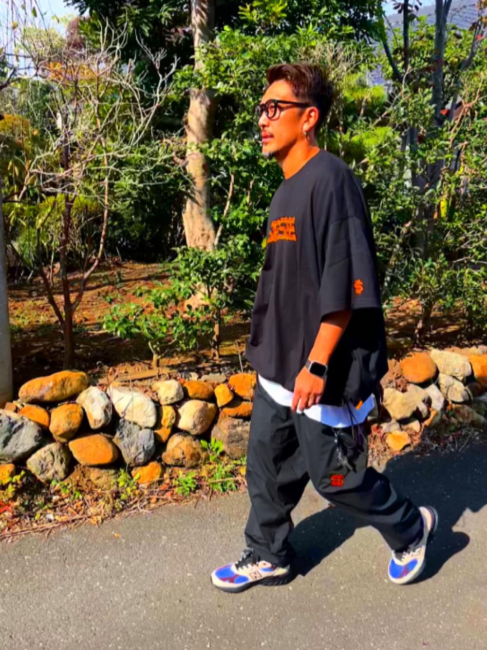 ブラック系のTシャツ/カットソー、ブラック系のその他パンツ、ホワイト系のスニーカーを着用したメンズの秋コーディネートの3枚目の写真
