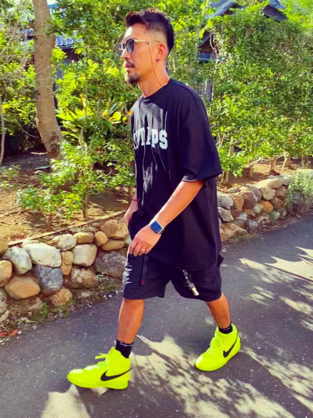 ブラック系のTシャツ/カットソー、ブラック系のカーゴパンツ、イエロー系のスニーカーを着用したメンズの夏コーディネートの4枚目の写真