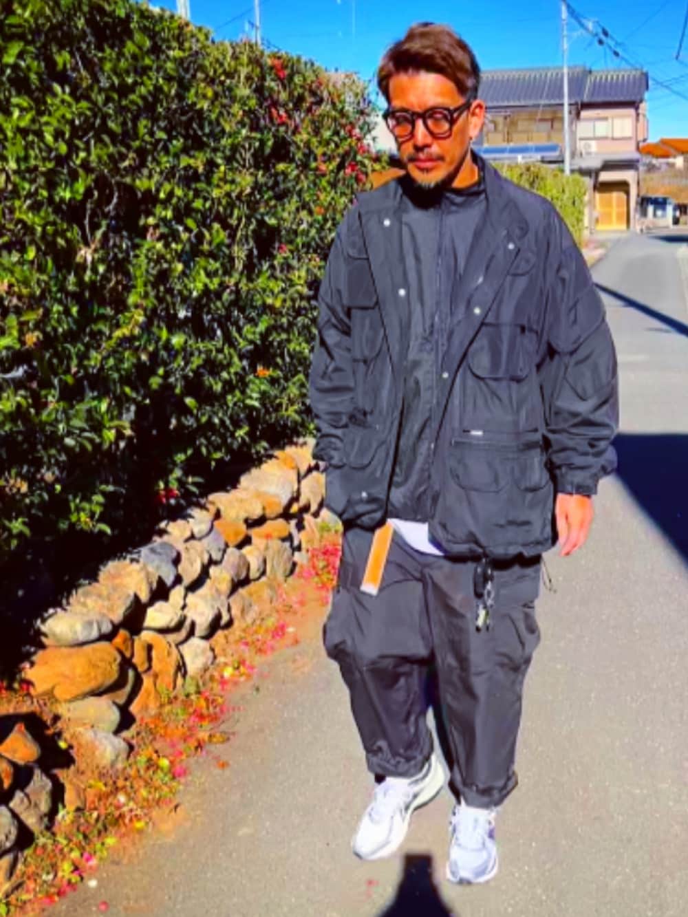 ブラック系のミリタリージャケット、ブラック系のTシャツ/カットソー、ブラック系のカーゴパンツを着用したメンズの冬コーディネートの2枚目の写真