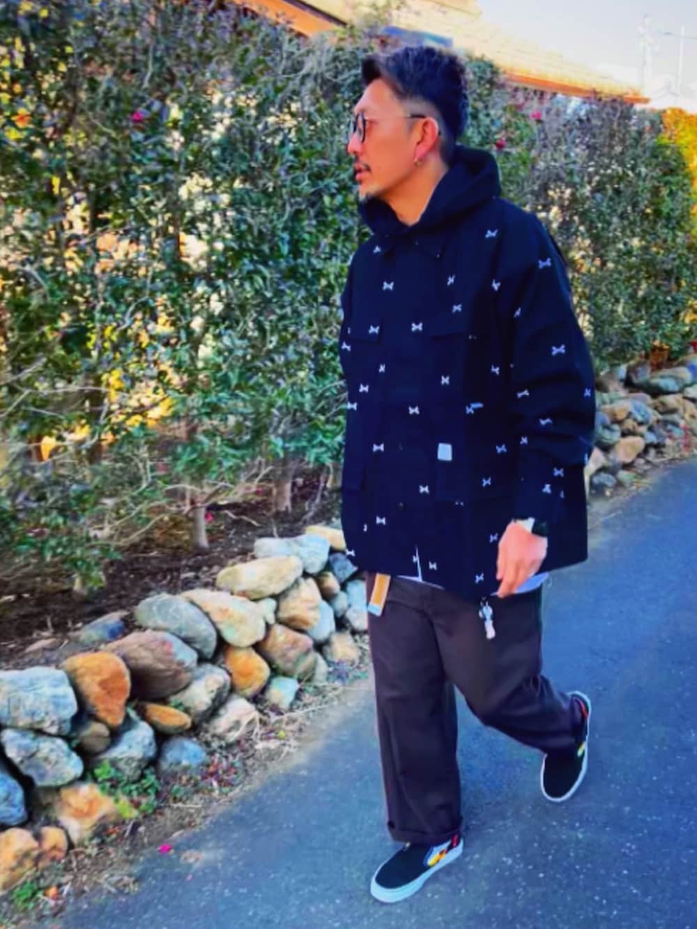 ブラック系のジャケット/アウター、ブラック系のパーカー、レッド系のチノパンツを着用したメンズの冬コーディネートの4枚目の写真