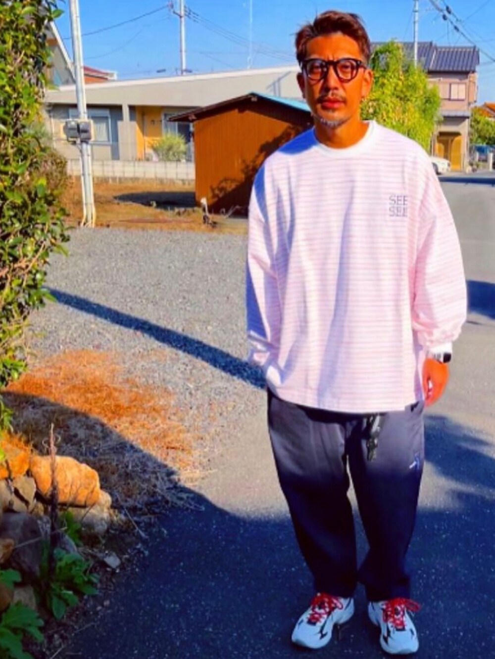 ホワイト系のTシャツ/カットソー、ブルー系のその他パンツ、ホワイト系のスニーカーを着用したメンズの秋コーディネートの2枚目の写真