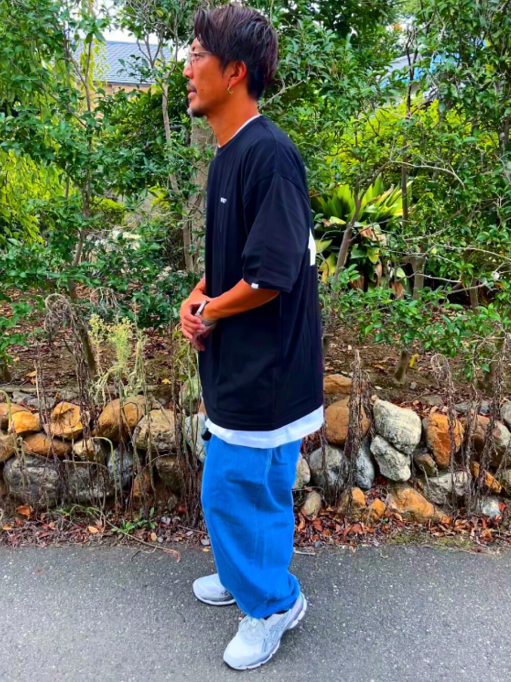 ブラック系のTシャツ/カットソー、ブルー系のデニムパンツ、グレー系のスニーカーを着用したメンズの秋コーディネートの4枚目の写真