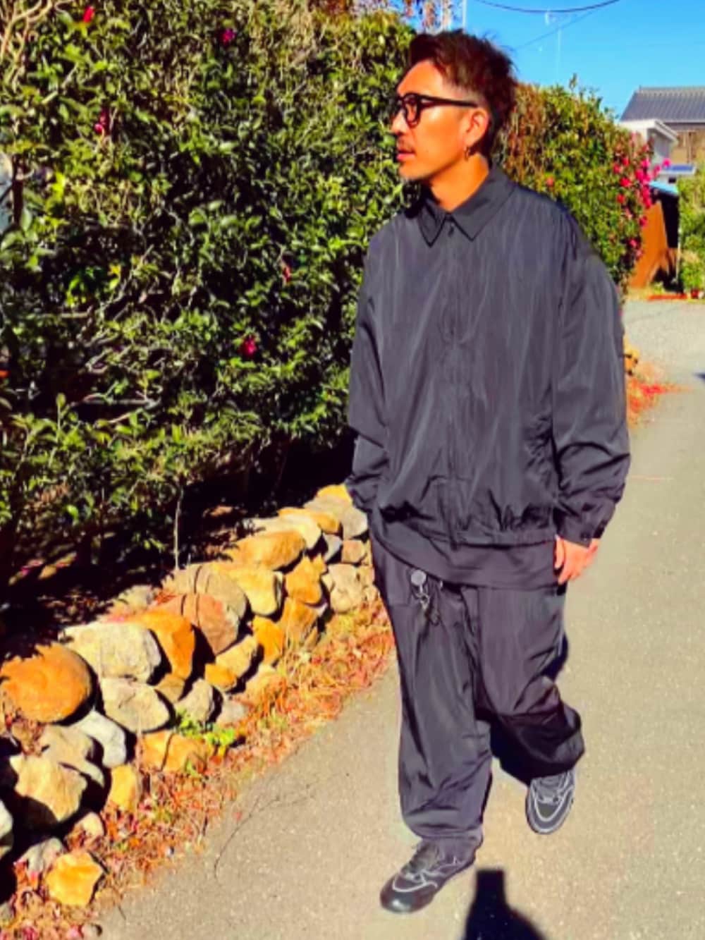 ブラック系のナイロンジャケット、ブラック系のその他パンツ、ブラック系のスニーカーを着用したメンズの冬コーディネートの3枚目の写真