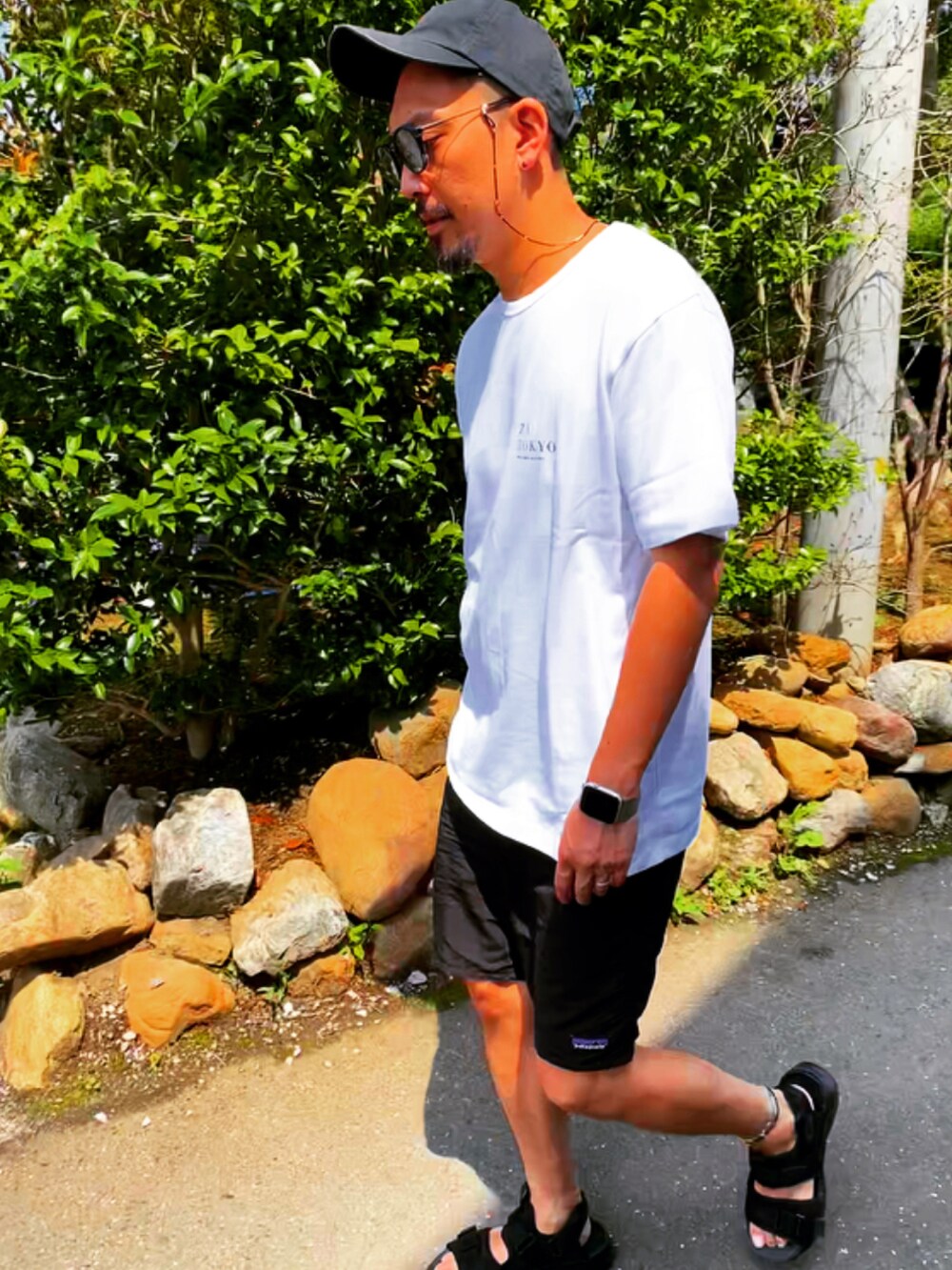 ホワイト系のTシャツ/カットソー、ブラック系のその他パンツ、ブラック系のサンダルを着用したメンズの夏コーディネートの4枚目の写真