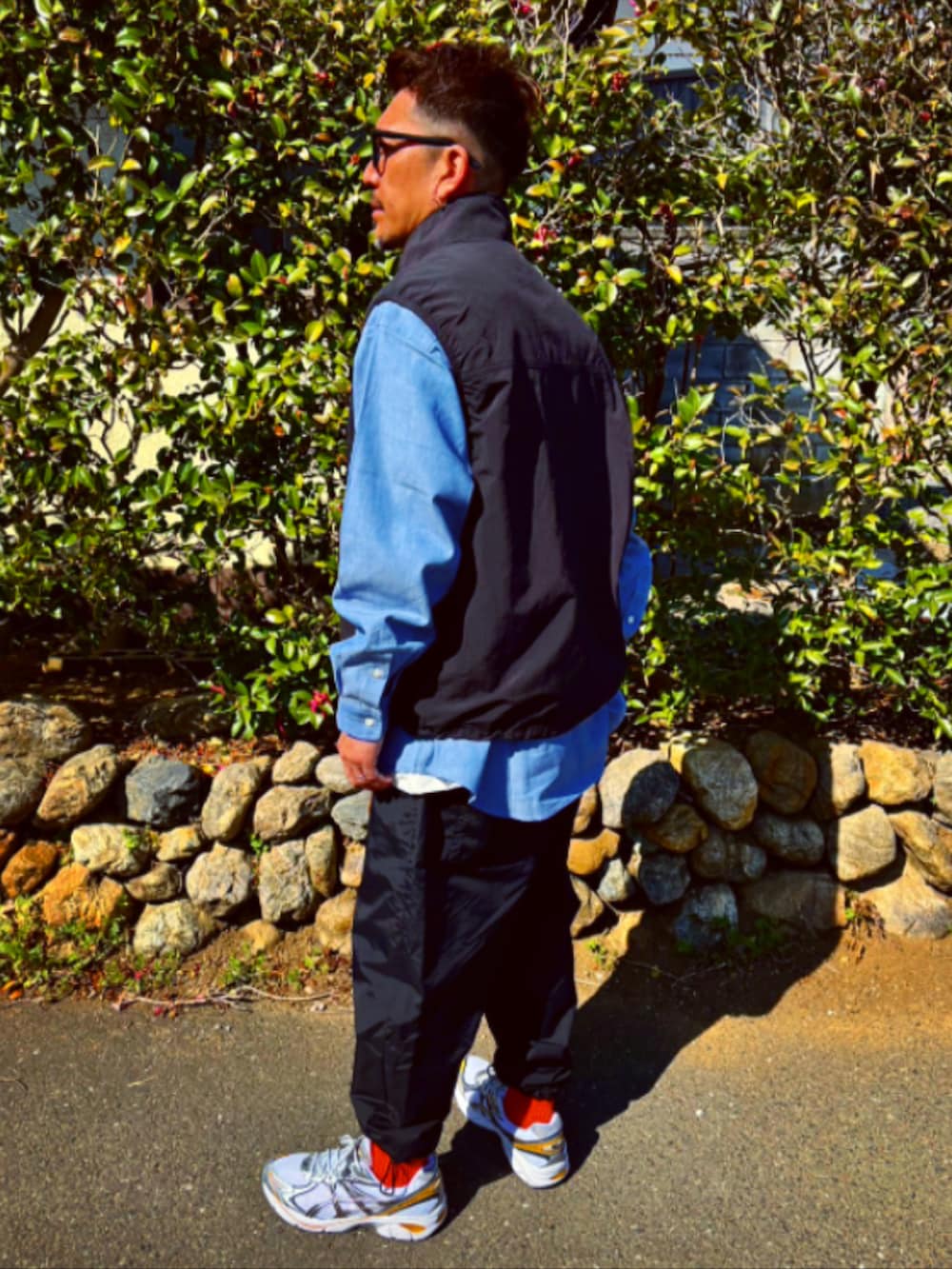 ブラック系のダウンベスト、ブルー系のシャツ/ブラウス、ブラック系のその他パンツを着用したメンズの春コーディネートの5枚目の写真