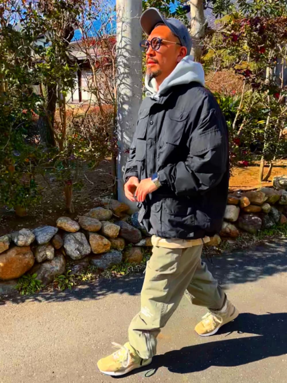 ブラック系のミリタリージャケット、グレー系のパーカー、グリーン系のその他パンツを着用したメンズの冬コーディネートの4枚目の写真