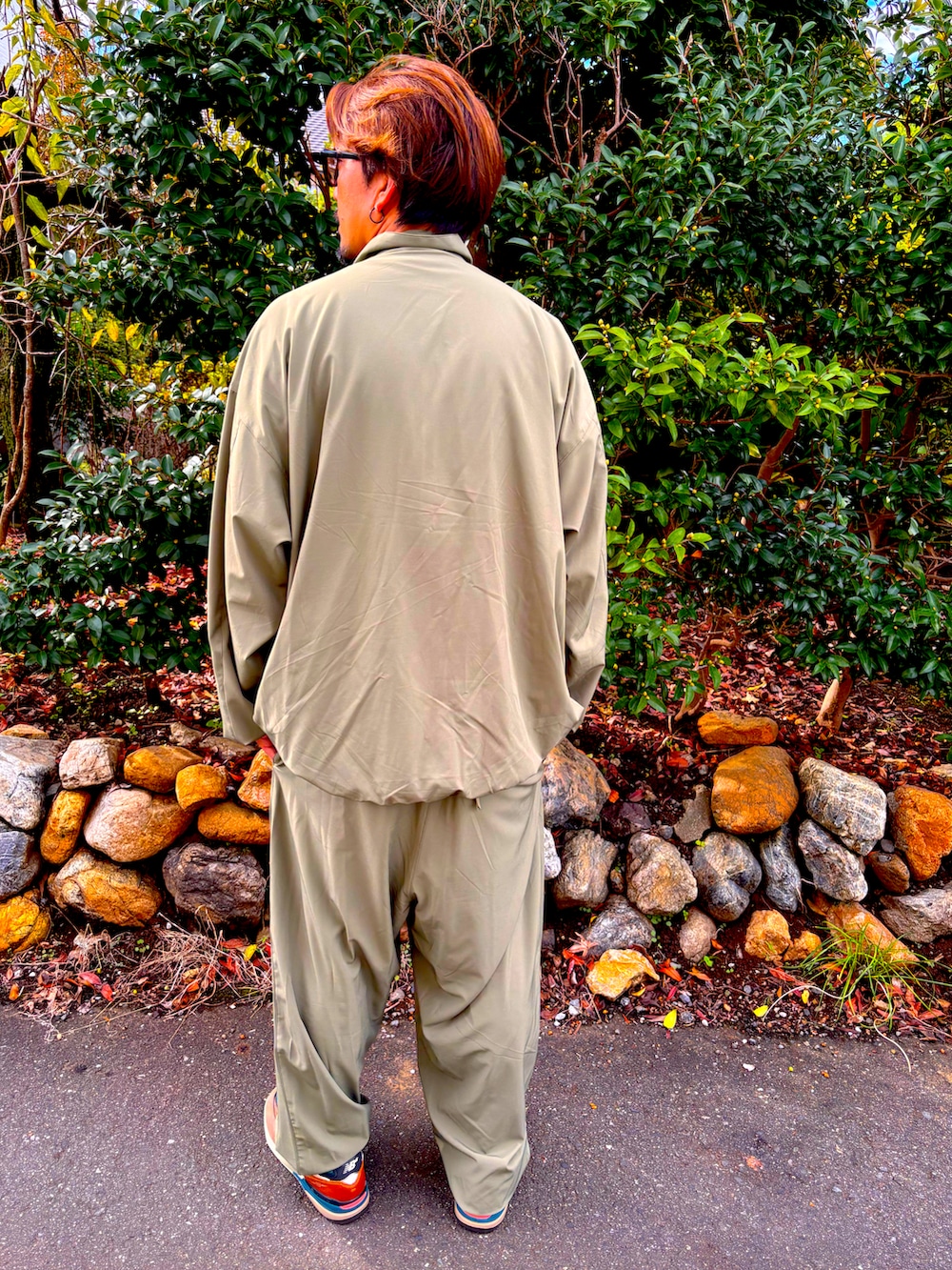 グリーン系のセットアップ、グリーン系のその他パンツ、ブラウン系のスニーカーを着用したメンズの秋コーディネートの5枚目の写真