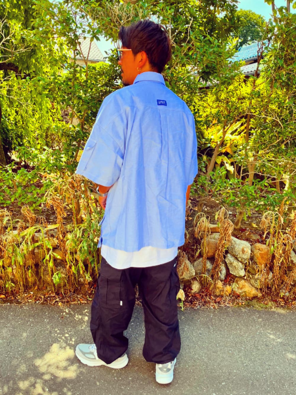 ブルー系のシャツ/ブラウス、ブラック系のカーゴパンツ、グレー系のスニーカーを着用したメンズの夏コーディネートの5枚目の写真