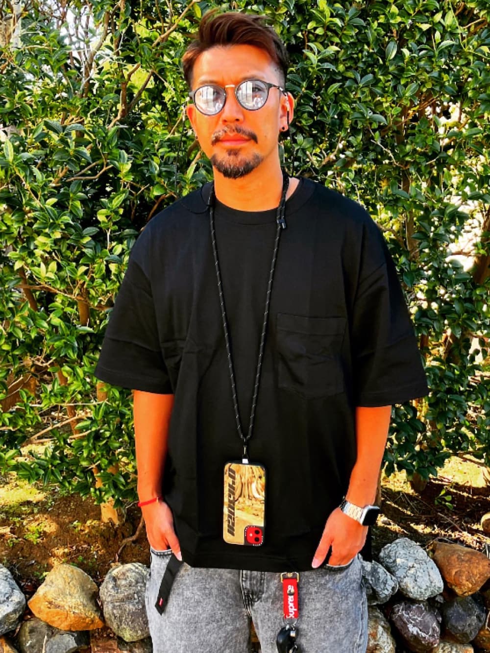 ブラック系のTシャツ/カットソー、グレー系のデニムパンツ、グレー系のスニーカーを着用したメンズの秋コーディネートの2枚目の写真