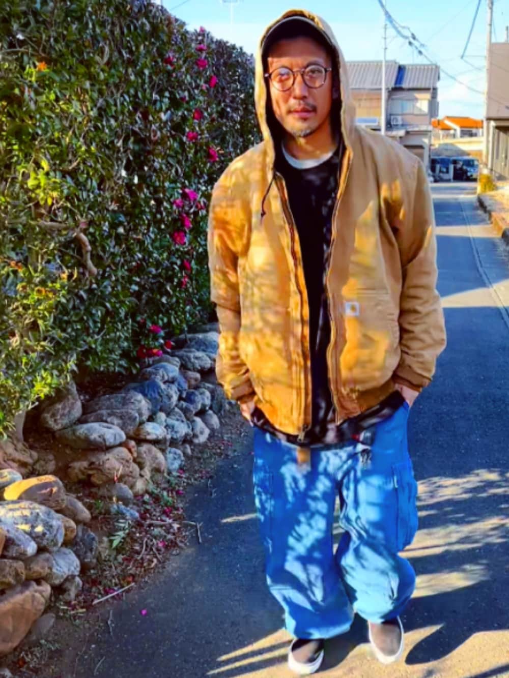 ブラウン系のブルゾン、ブラック系のTシャツ/カットソー、ブルー系のカーゴパンツを着用したメンズの冬コーディネートの2枚目の写真