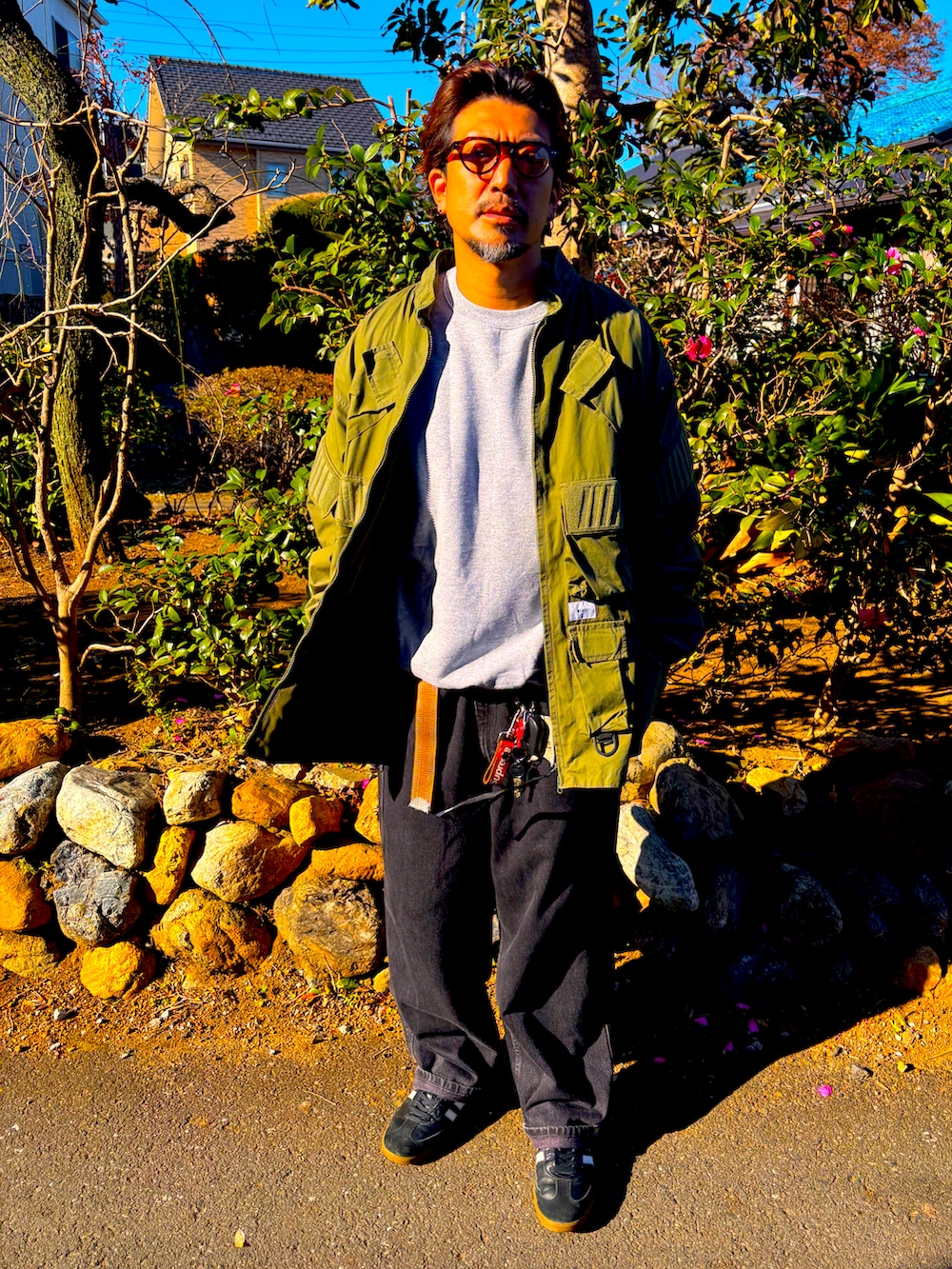 ブラック系のスニーカー、グレー系のスウェット、ブラック系のデニムパンツを着用したメンズの冬コーディネートの2枚目の写真