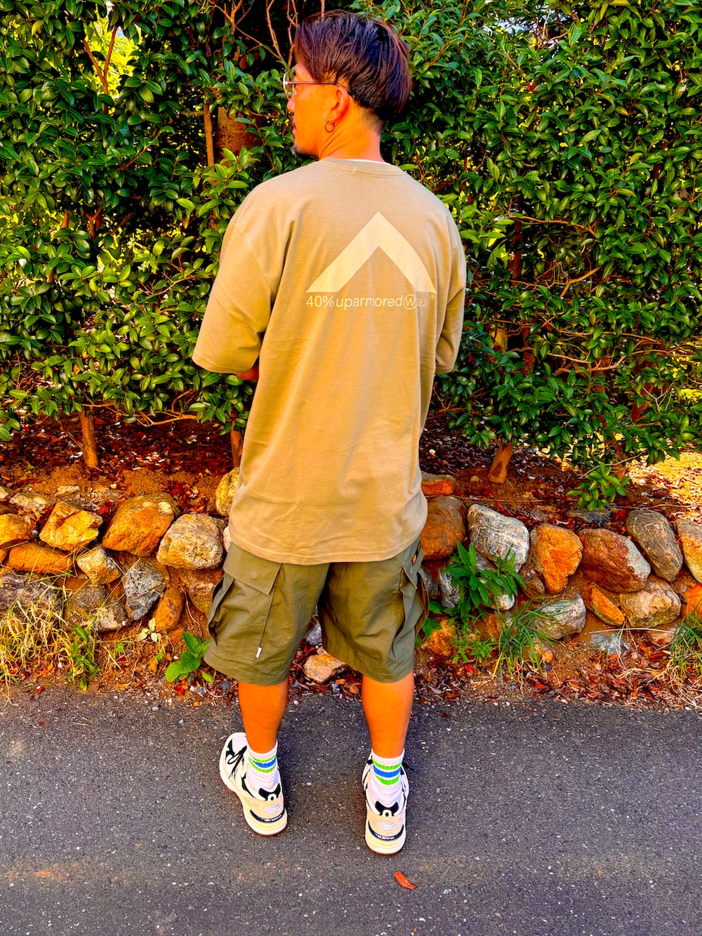 グリーン系のTシャツ/カットソー、グリーン系のその他パンツ、ホワイト系のスニーカーを着用したメンズの夏コーディネートの4枚目の写真