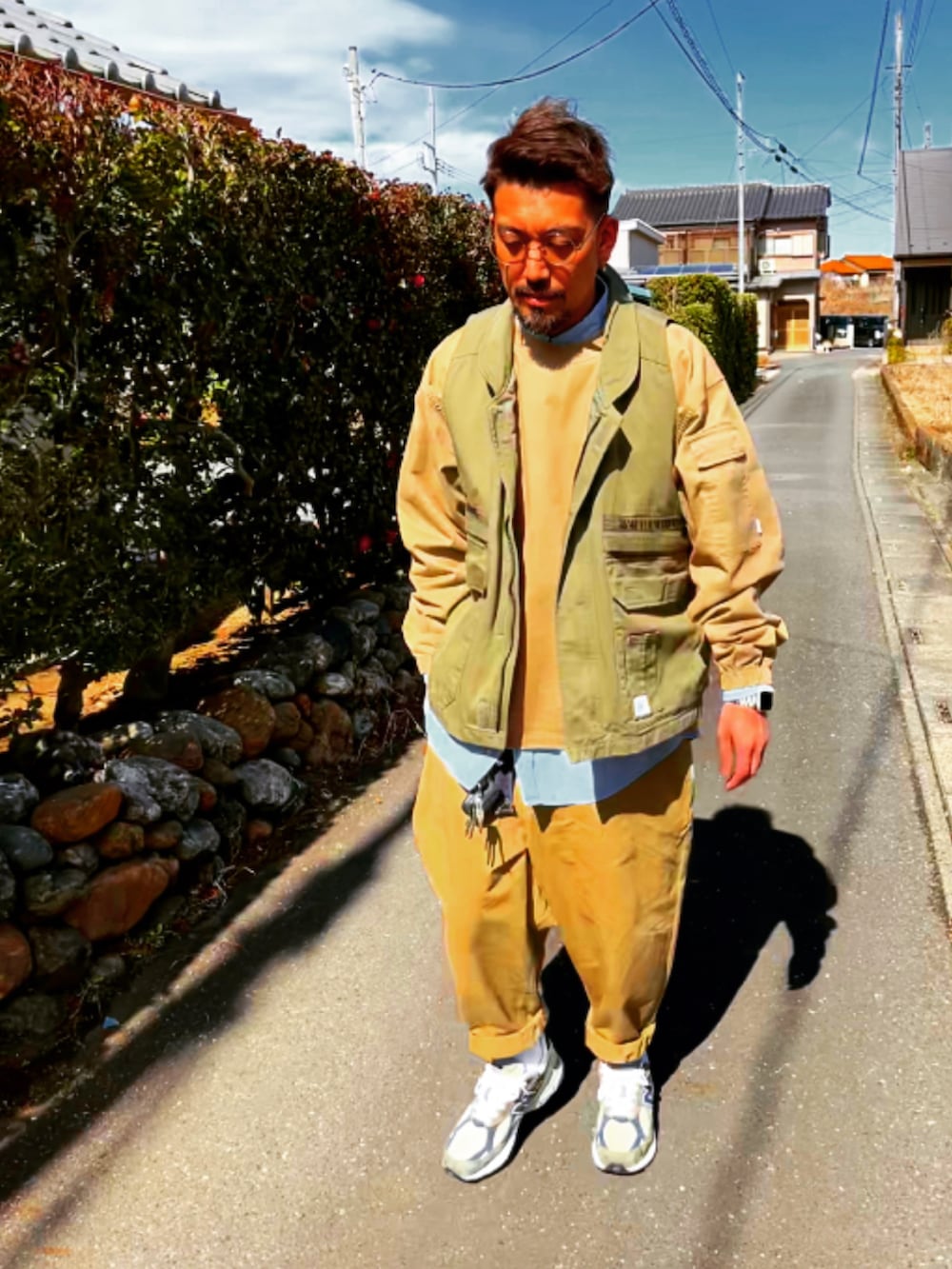 グリーン系のベスト、ベージュ系のトップス、ブルー系のシャツ/ブラウスを着用したメンズの春コーディネートの4枚目の写真