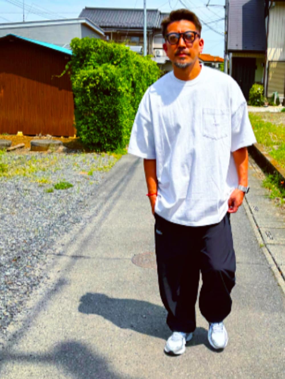 グレー系のTシャツ/カットソー、ブラック系のその他パンツ、ホワイト系のスニーカーを着用したメンズの春コーディネートの5枚目の写真