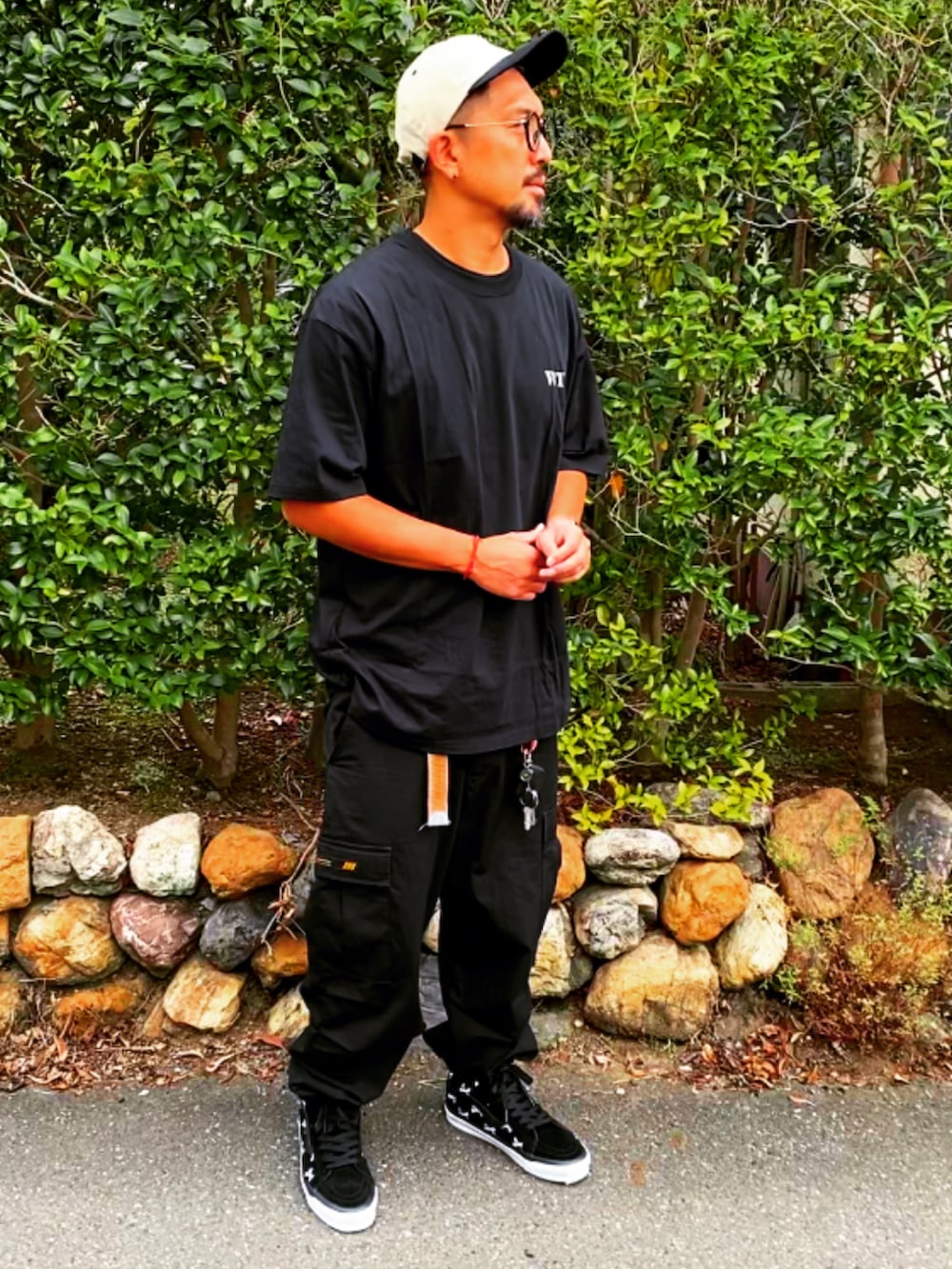 ブラック系のTシャツ/カットソー、ブラック系のカーゴパンツ、ブラック系のスニーカーを着用したメンズの夏コーディネートの3枚目の写真